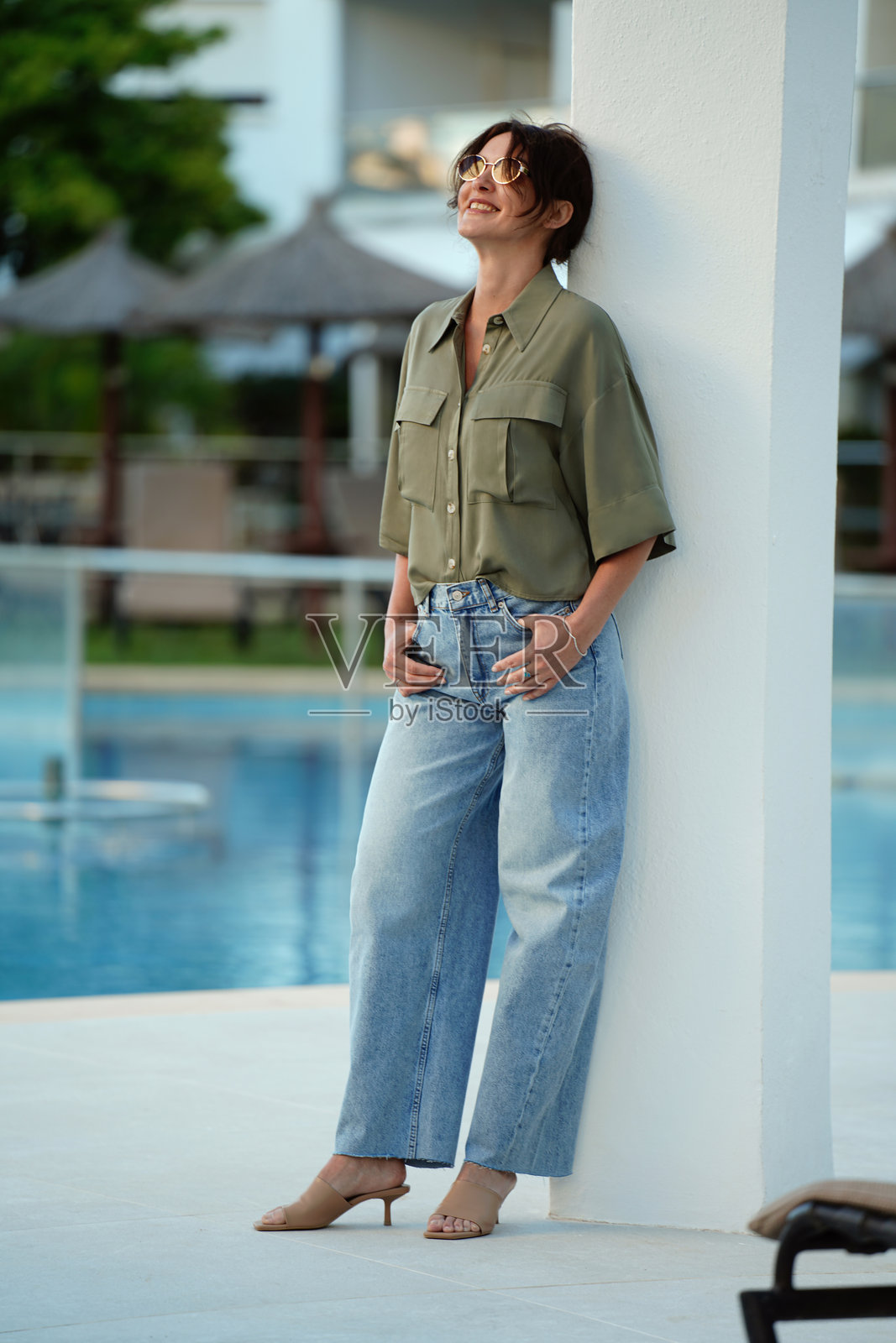 时尚美丽的女子在泳池边放松，一位迷人的女士。照片摄影图片