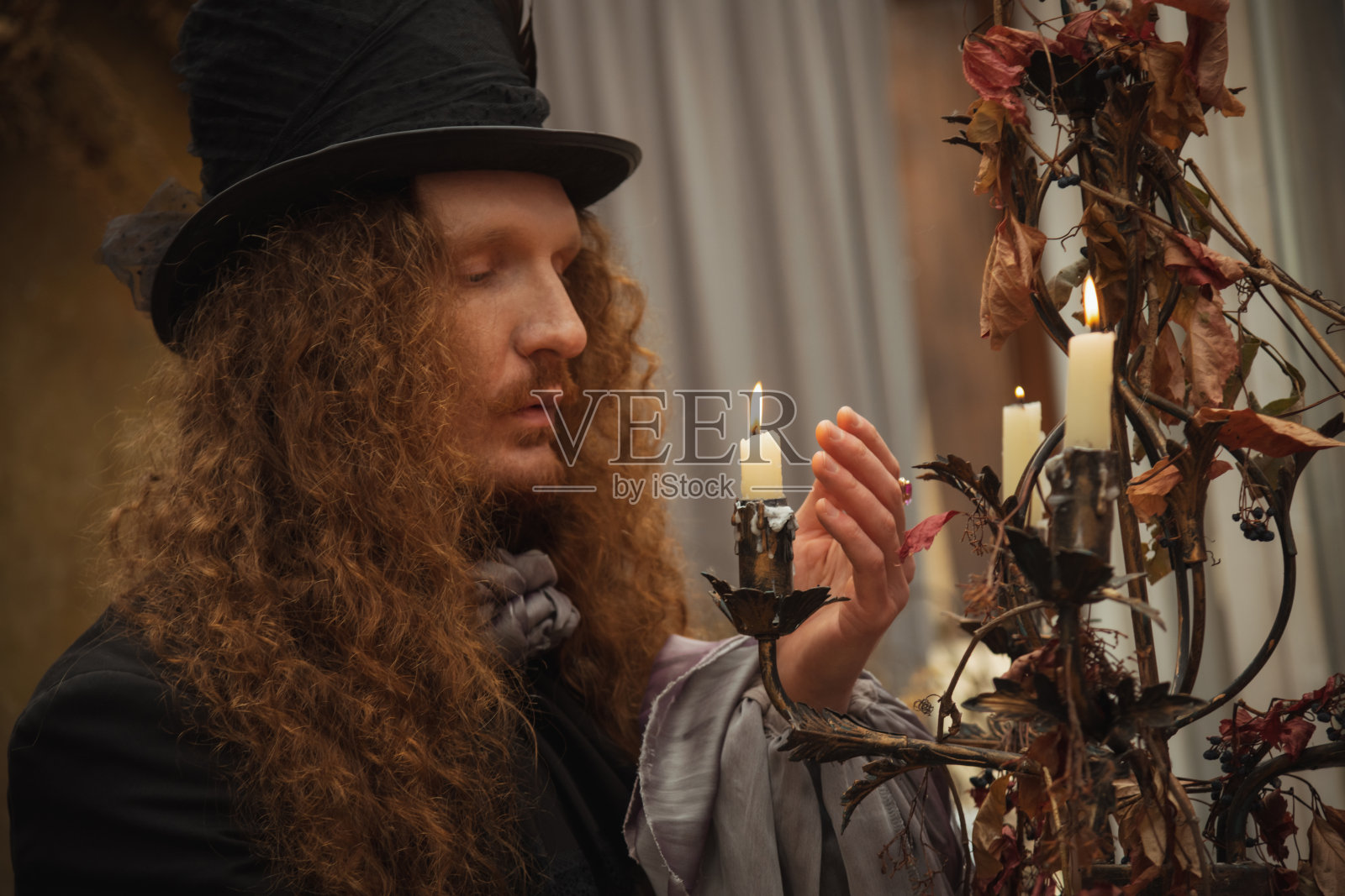 维多利亚时代着装的男士在昏暗的聚会上点燃蜡烛照片摄影图片