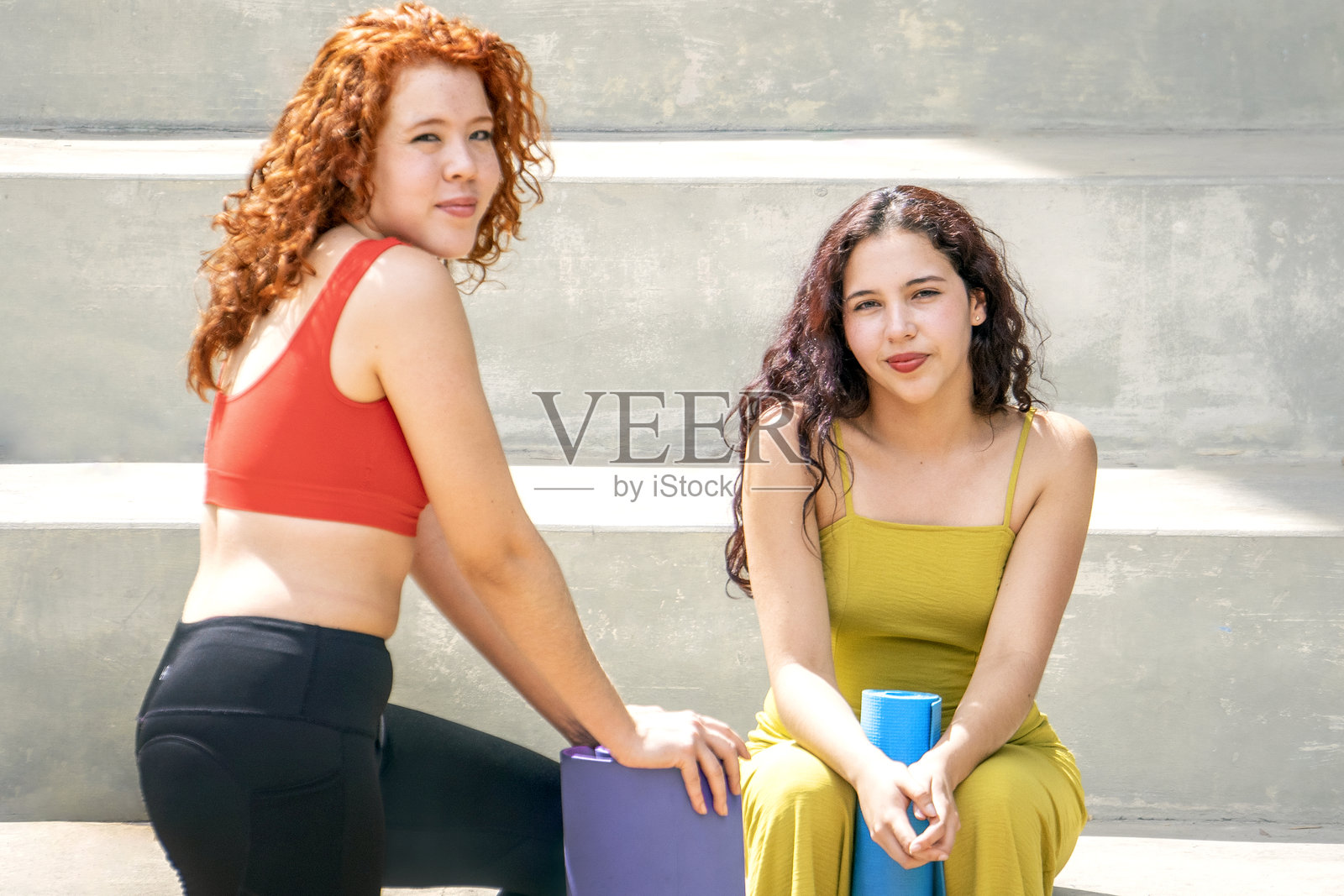 两位女士坐在楼梯上，其中一位穿着红色上衣照片摄影图片