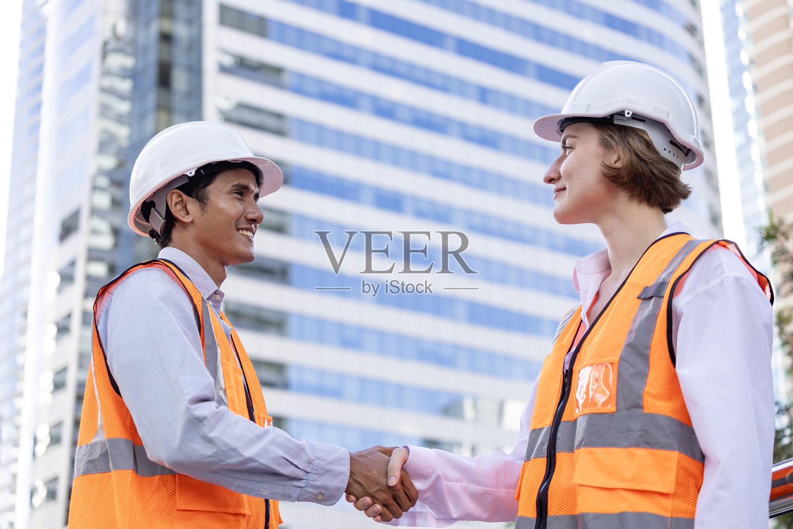 多元化团队在检查完现代建筑和房地产开发项目移交概念后握手照片摄影图片