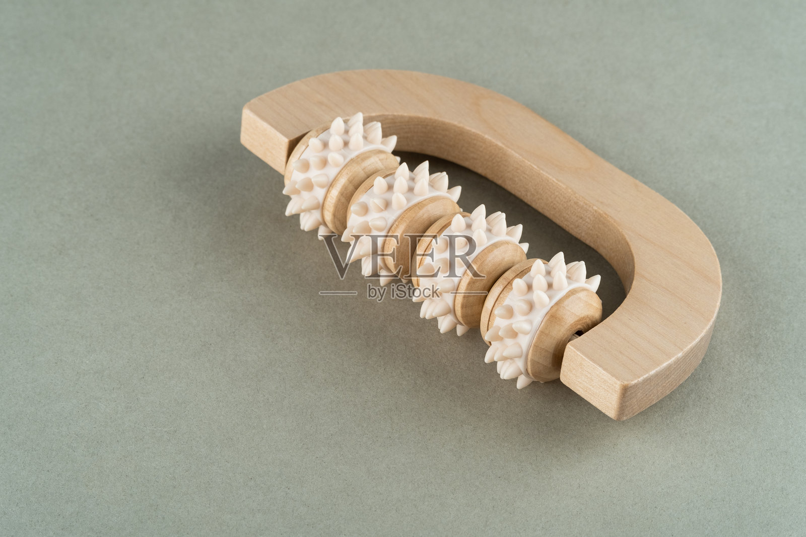 带有纹理滚轴的木制按摩滚轮，专为放松和缓解肌肉而设计，展示了天然材料和符合人体工程学的形状，可用于有效的自我护理疗程照片摄影图片