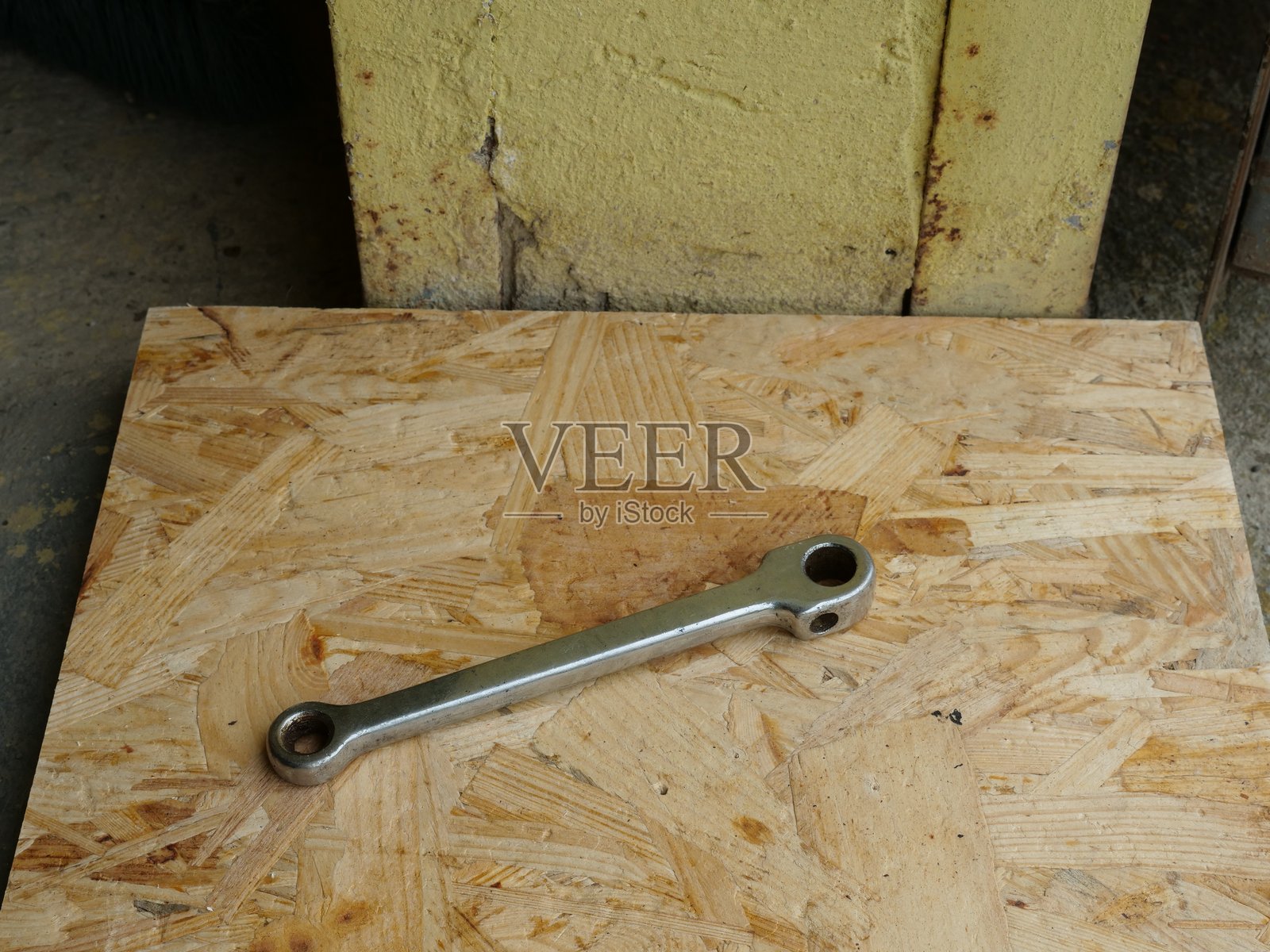 金属杠杆或连杆放在木板上，车间里的机械零件。照片摄影图片