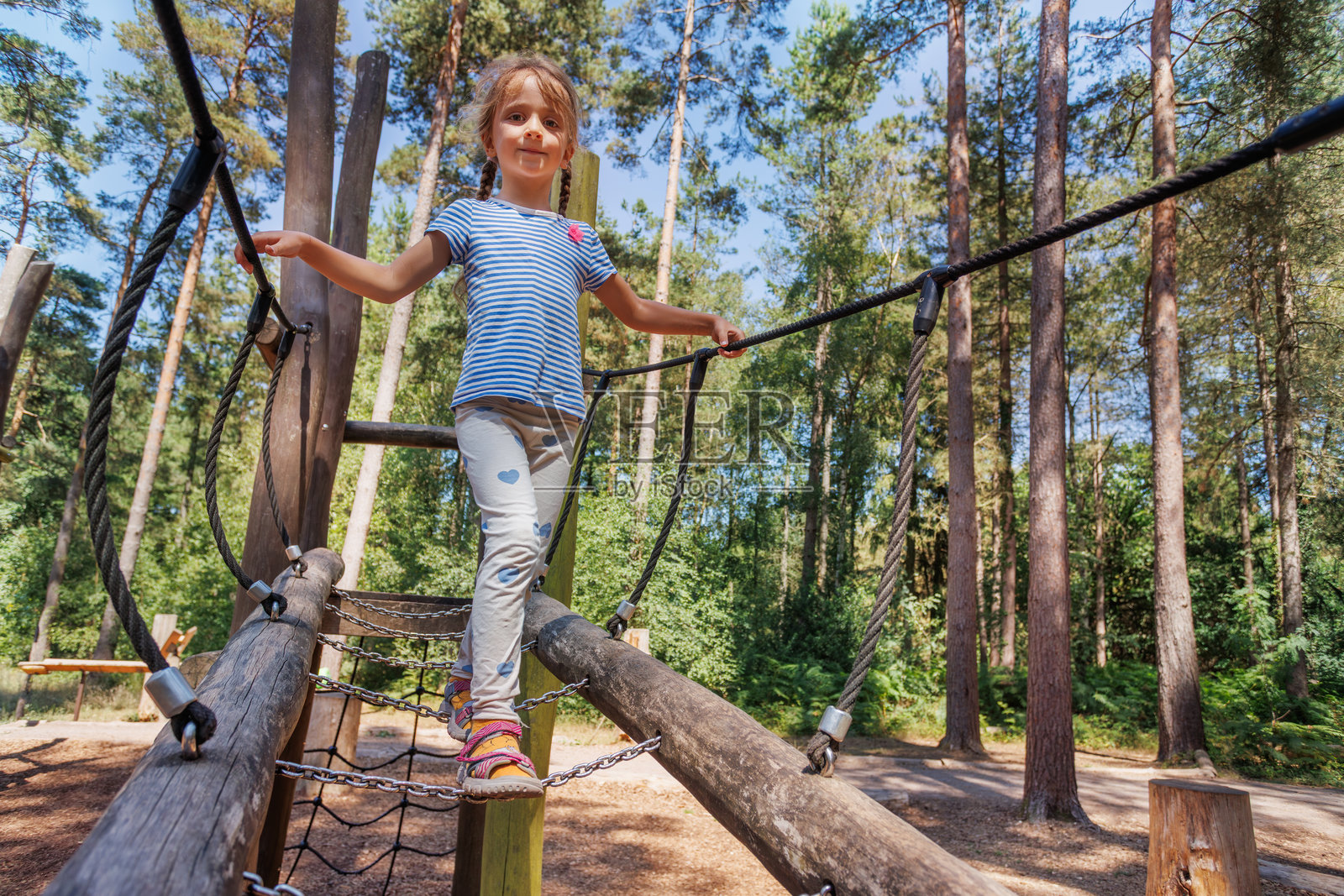 小女孩在户外的木制游乐设施上玩耍照片摄影图片
