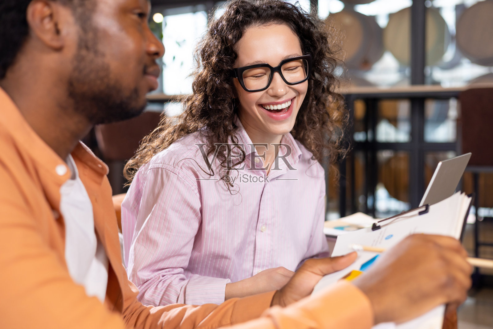 戴眼镜的女子笑着与同事交流照片摄影图片