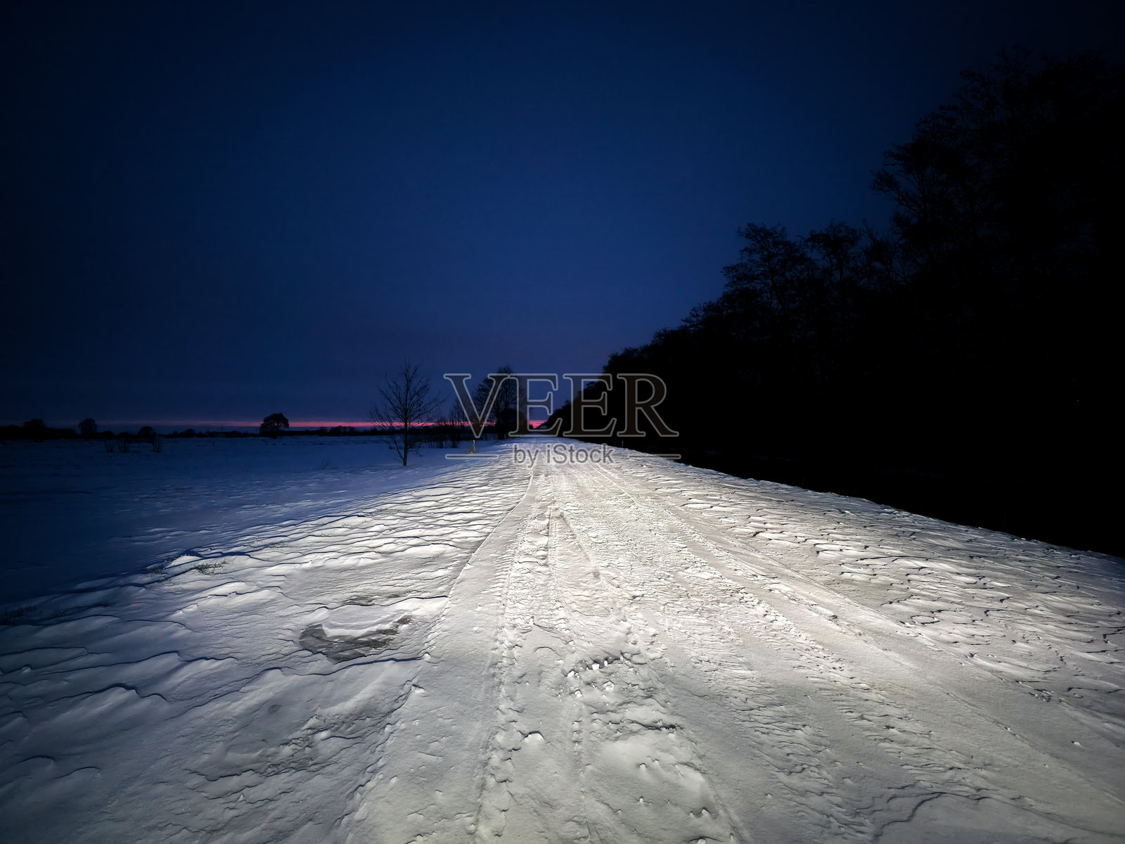 德国下萨克森州霍勒镇27798号，黄昏时分，白雪覆盖的街道，两旁是树木，冬季和雪景照片摄影图片