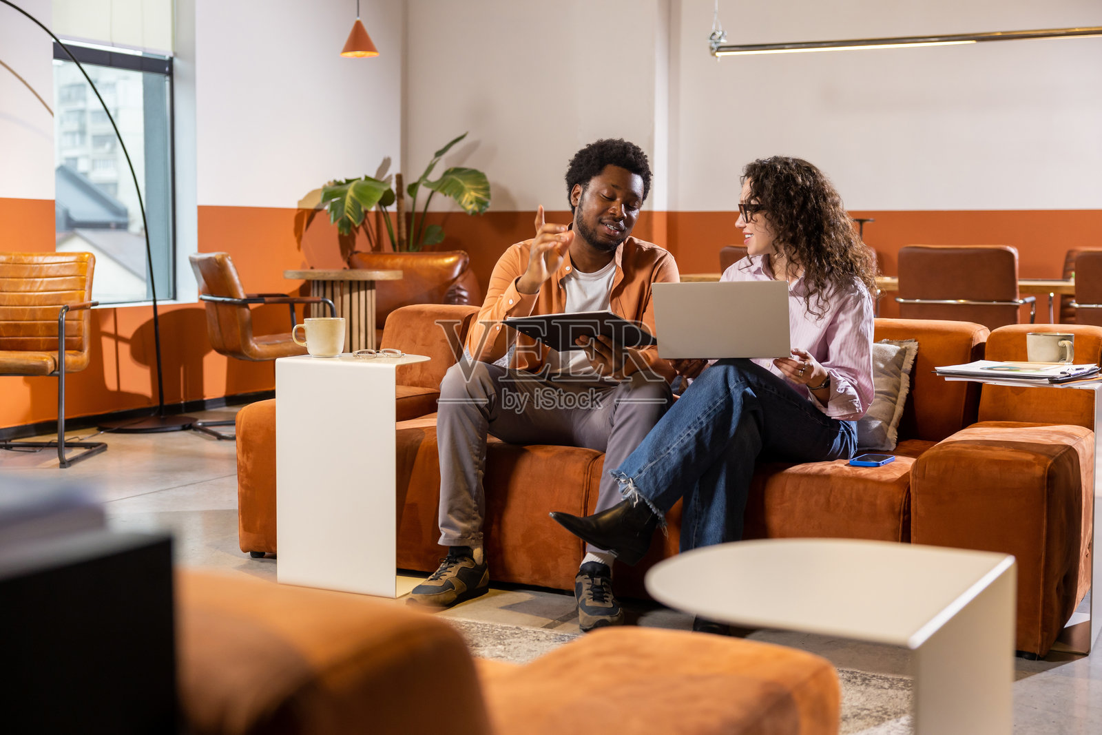 微笑着的同事们协作，手中拿着笔记本电脑和平板电脑照片摄影图片