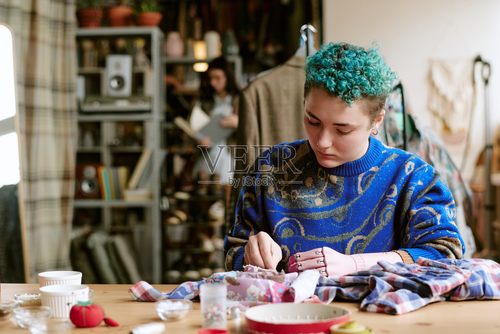 年轻的白种人女性在工作室修理二手衣物照片摄影图片