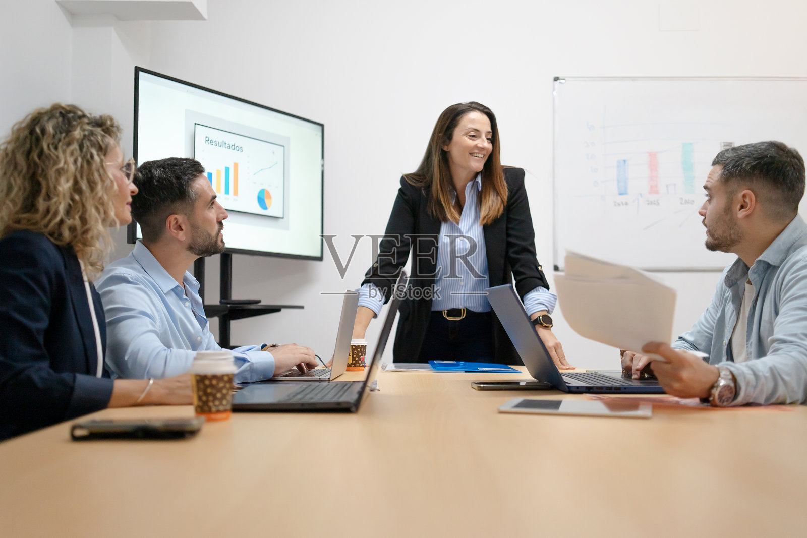 女商人带领多元化团队开会，讨论成果照片摄影图片