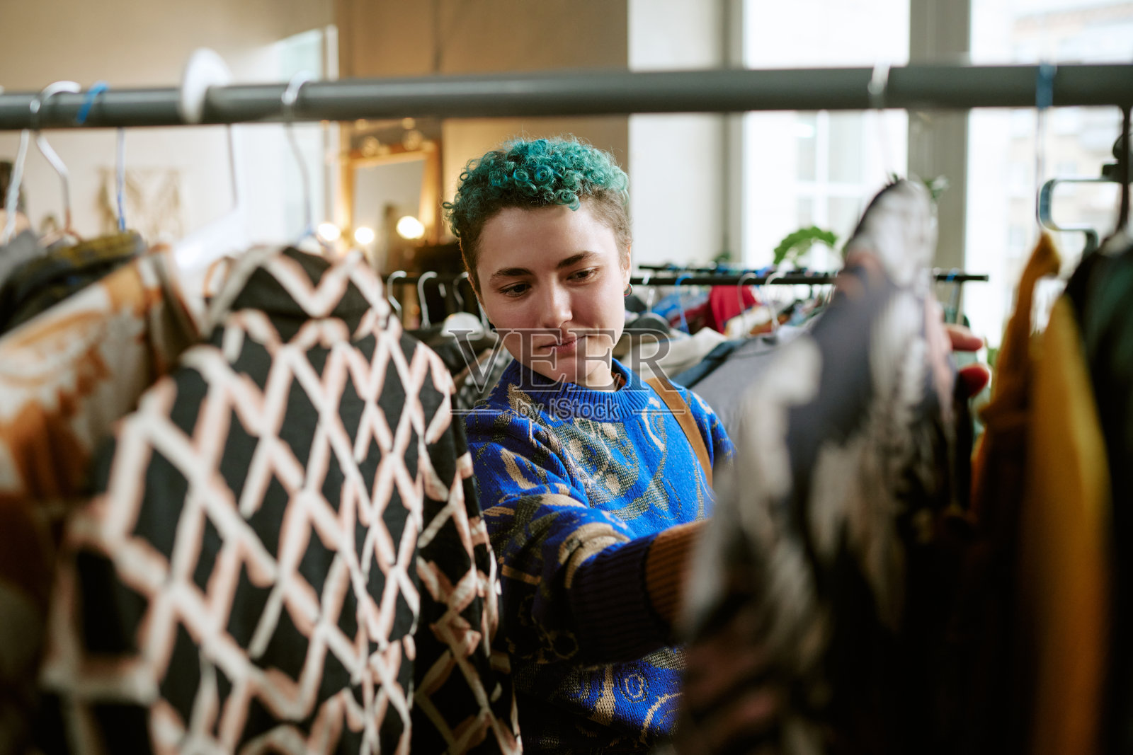 年轻白人女性在二手店浏览旧衣照片摄影图片