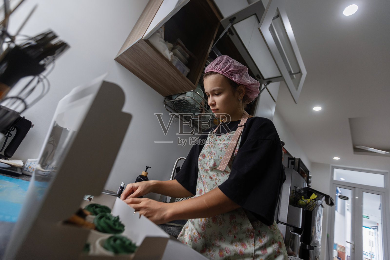 年轻女性在厨房烘焙纸杯蛋糕照片摄影图片