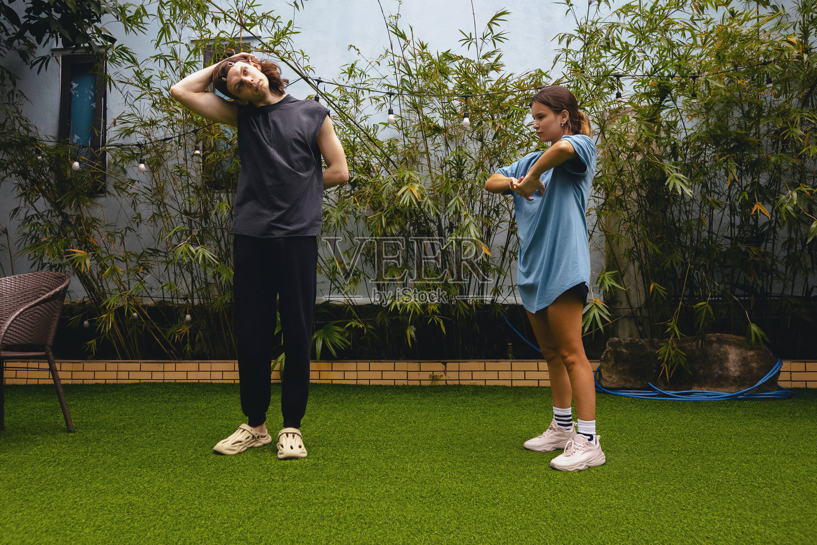 白人成年男性与年轻女性在户外做伸展运动照片摄影图片