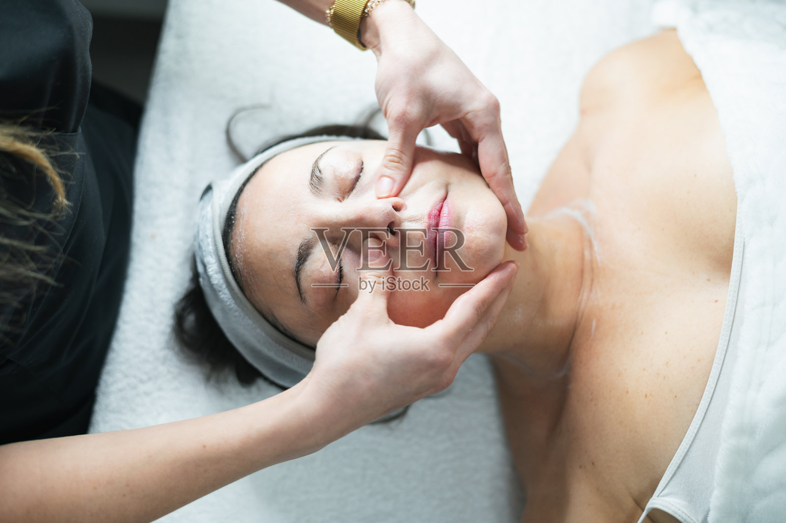 美容师在水疗中心为女子做放松面部按摩照片摄影图片