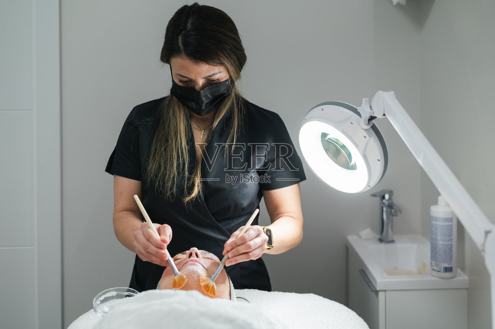 美容师在进行皮肤护理时敷面膜照片摄影图片