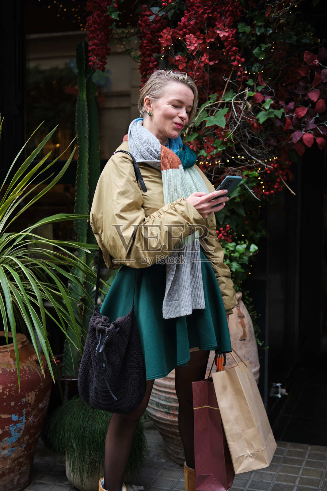现代女性在城市购物后查看智能手机照片摄影图片