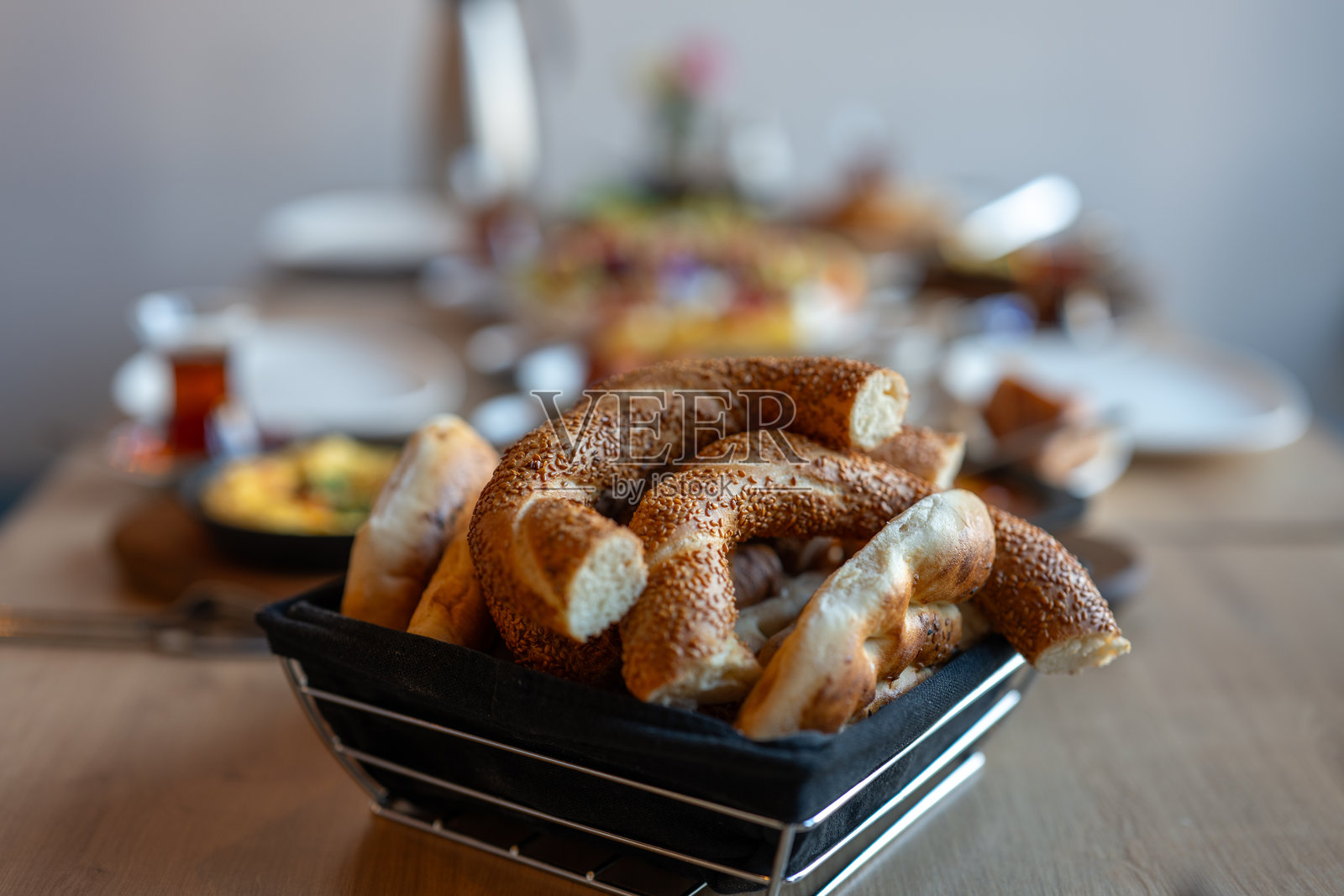 黑篮子里的芝麻贝果放在木桌上，适合早餐或早午餐，传统的土耳其西米特面包，适用于餐厅菜单照片摄影图片