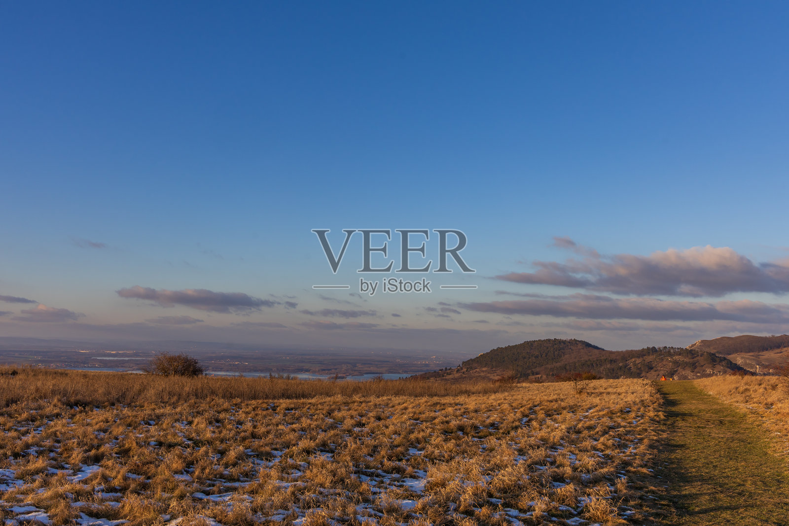 从特热宾山到新磨坊湖的全景。冬季帕拉瓦风景，有徒步小径和日落时的金色草地照片摄影图片