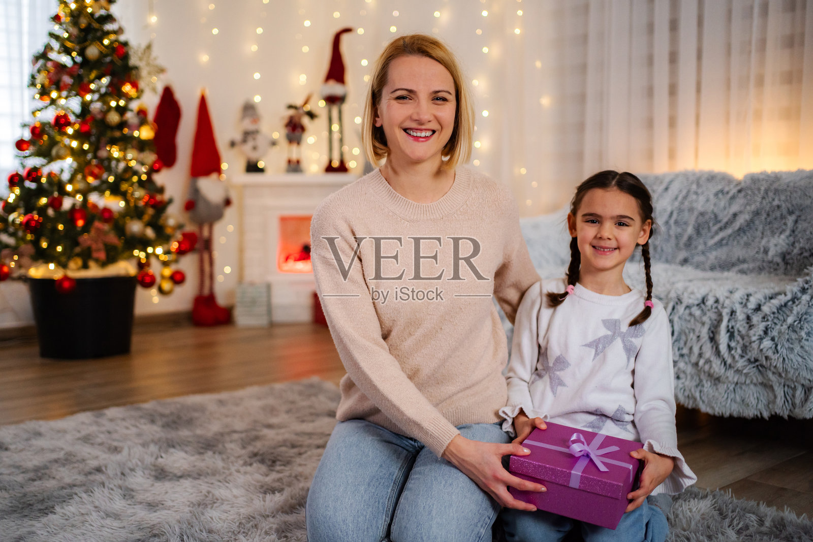 母亲和女儿在家中庆祝圣诞节，并互赠礼物照片摄影图片