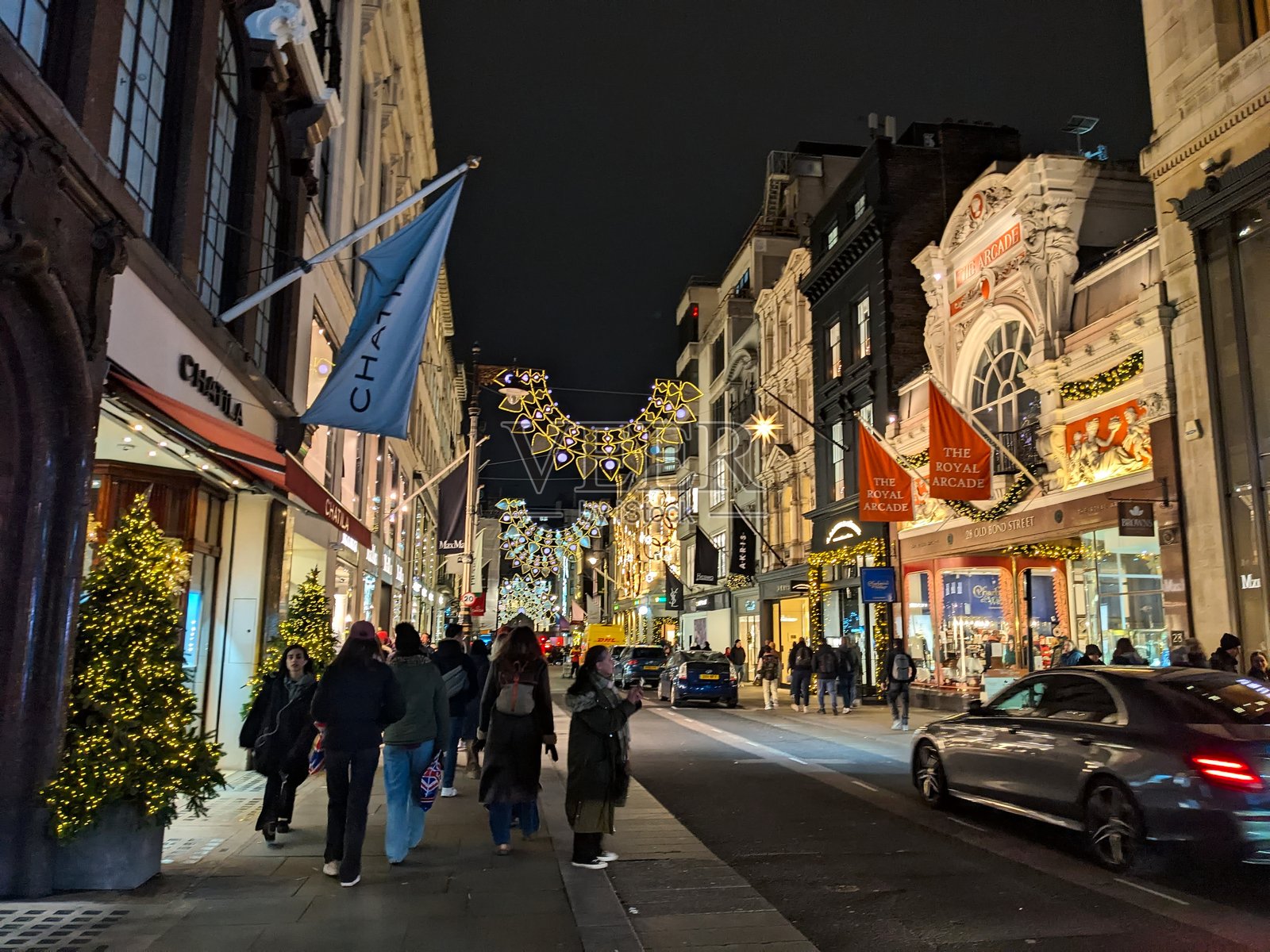 夜幕下的伦敦老邦德街，行人走过奢华精品店和皇家拱廊照片摄影图片