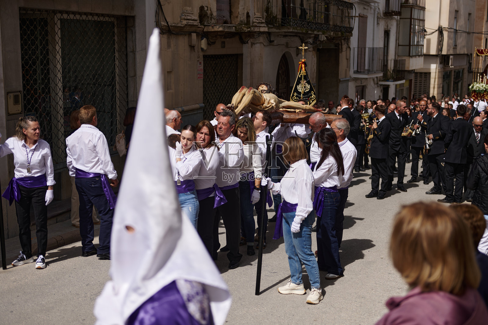 西班牙安达卢西亚省克萨达的宗教游行：参与者身着白色衬衫和紫色腰带，摄于2024年4月18日照片摄影图片