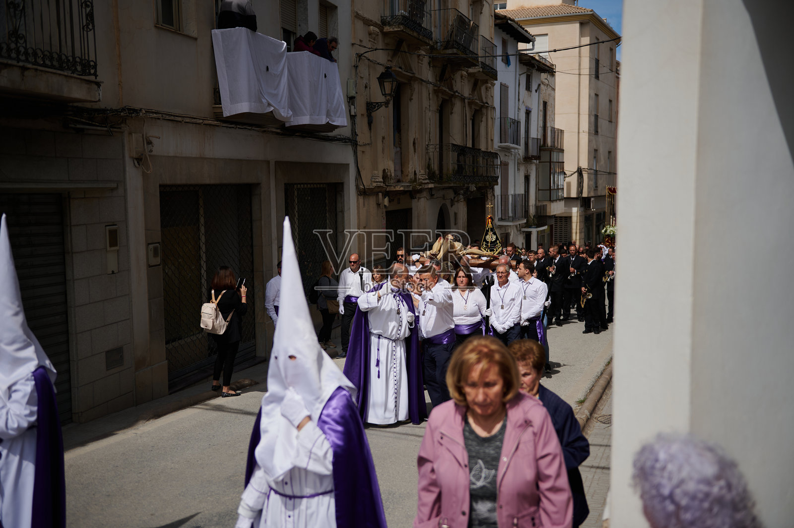 西班牙克萨达圣周期间狭窄安达卢西亚街道上的宗教游行，供编辑使用照片摄影图片