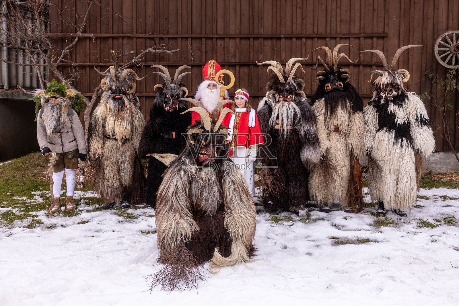 身着传统服饰的人们在节日期间聚集在雪地户外参加冬季庆典照片摄影图片