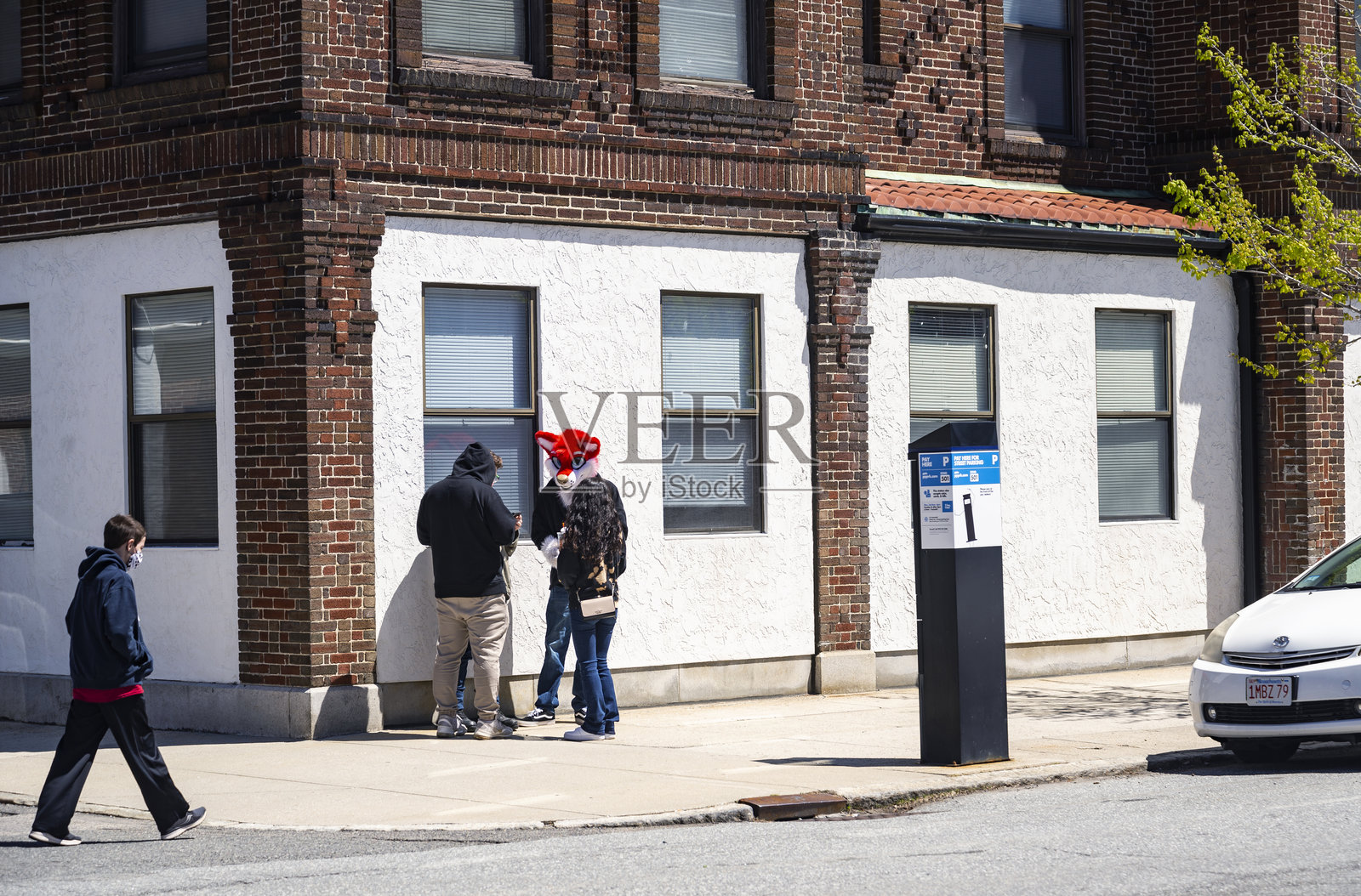 人们在美国马萨诸塞州洛厄尔市中心戴着口罩闲逛。照片摄影图片