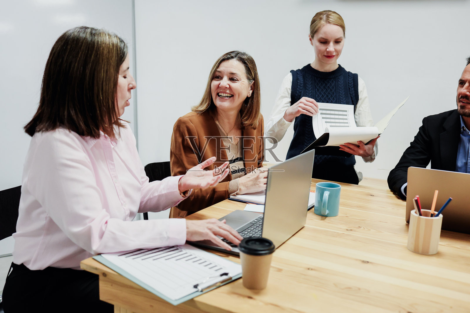 在办公室工作的西班牙裔中年女性，一起使用笔记本电脑。几位成熟的女企业家正在开会并分享想法。照片摄影图片