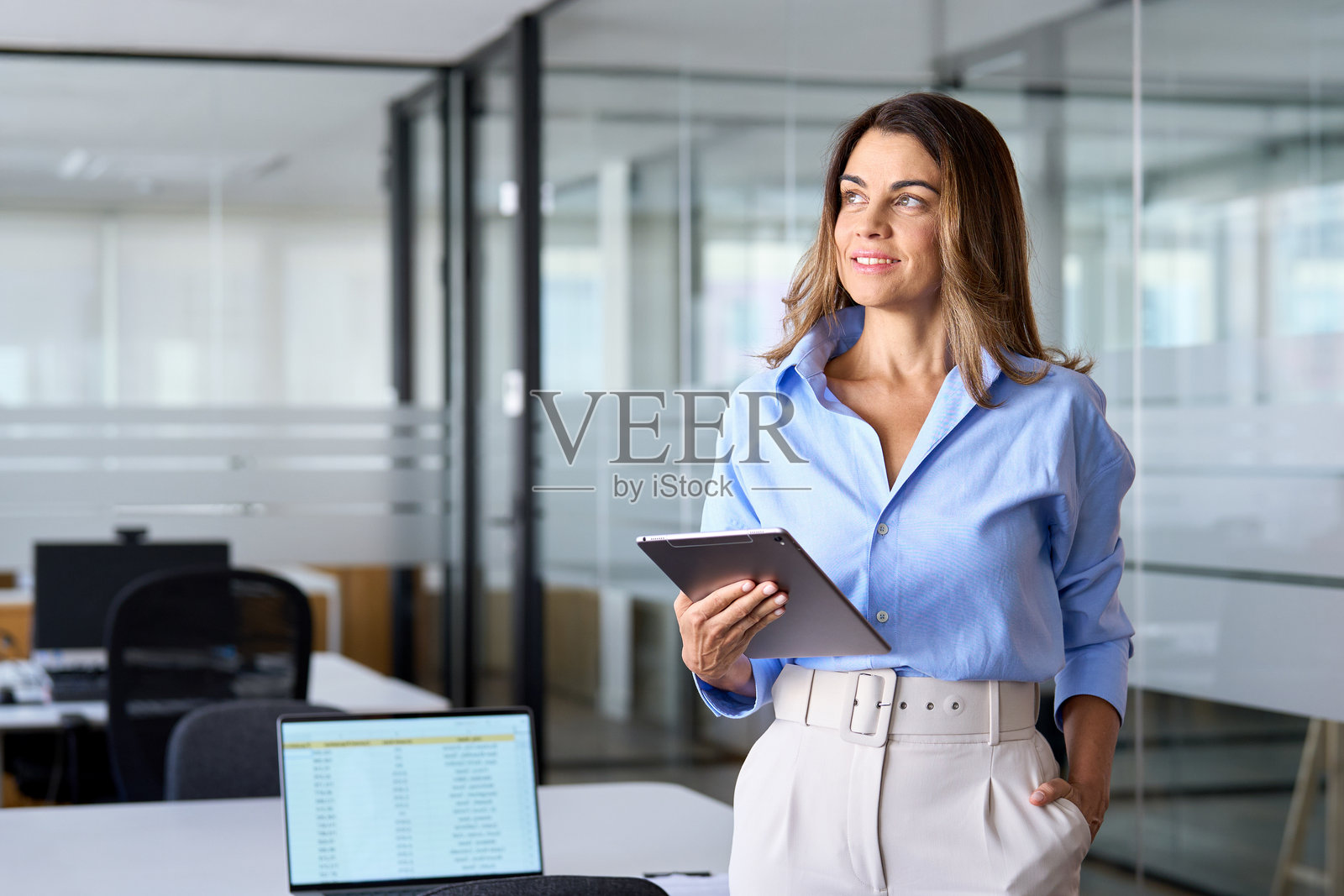 忙碌的中年女商人、经理在办公室使用平板电脑照片摄影图片