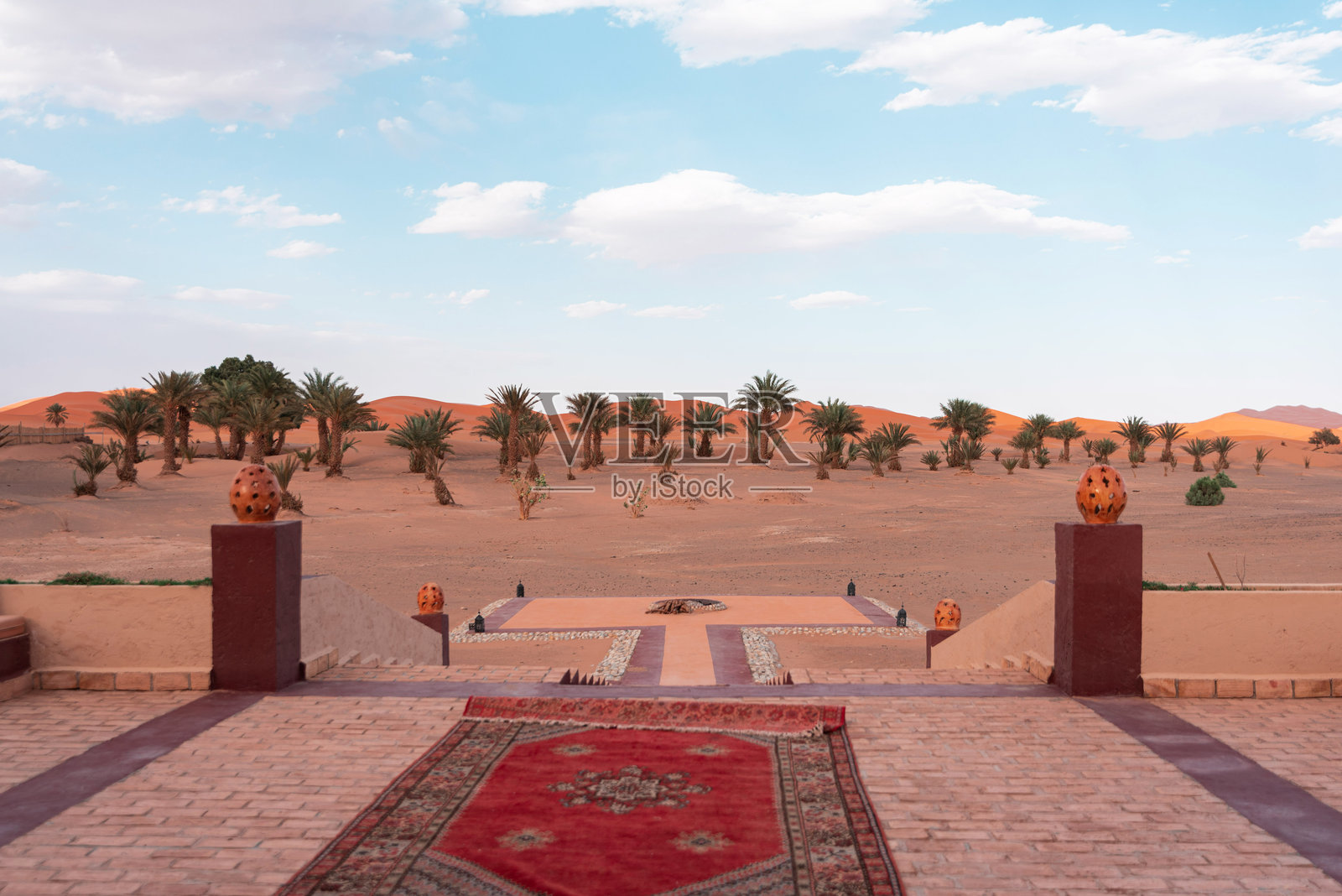 撒哈拉沙漠绿洲和沙丘的风景，从豪华酒店露台望去，铺有红毯并带有装饰照片摄影图片
