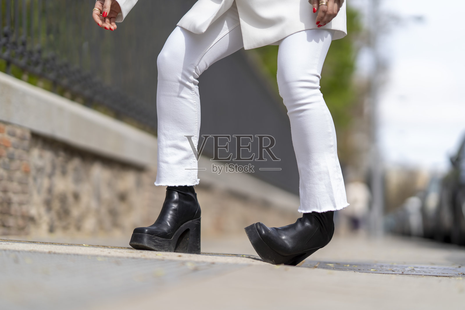 身穿白色喇叭裤和厚底靴的女性正在行走照片摄影图片