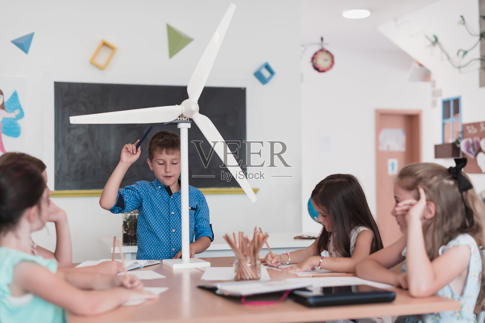 小学STEM机器人教室，一群多元化的孩子们正在建造和编程风力生态机器人概念。他们一起讨论，像团队一样合作。创意机器人工程。照片摄影图片