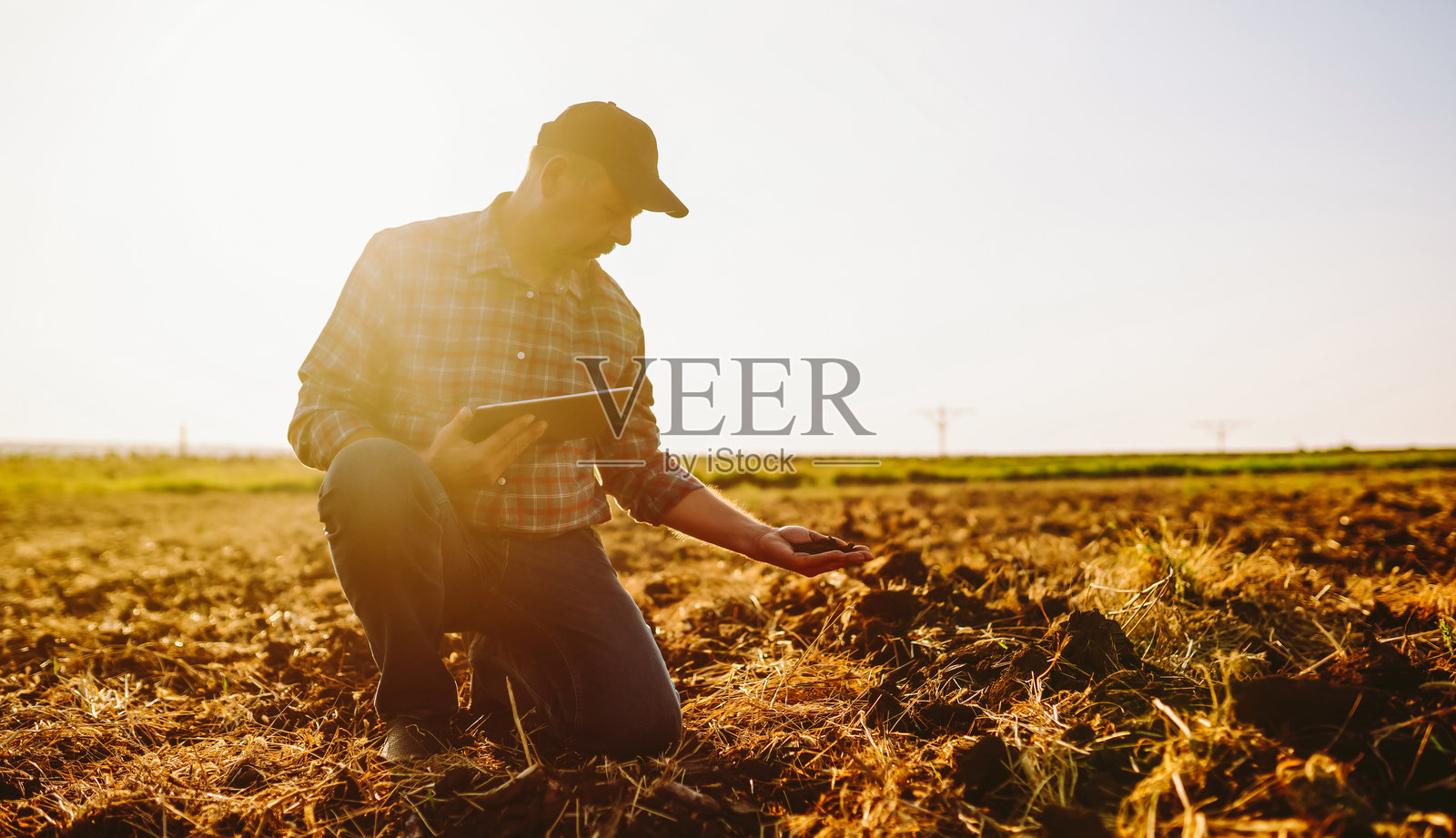 一位经验丰富的农夫，手持调查表，在播种前检查土壤质量。照片摄影图片