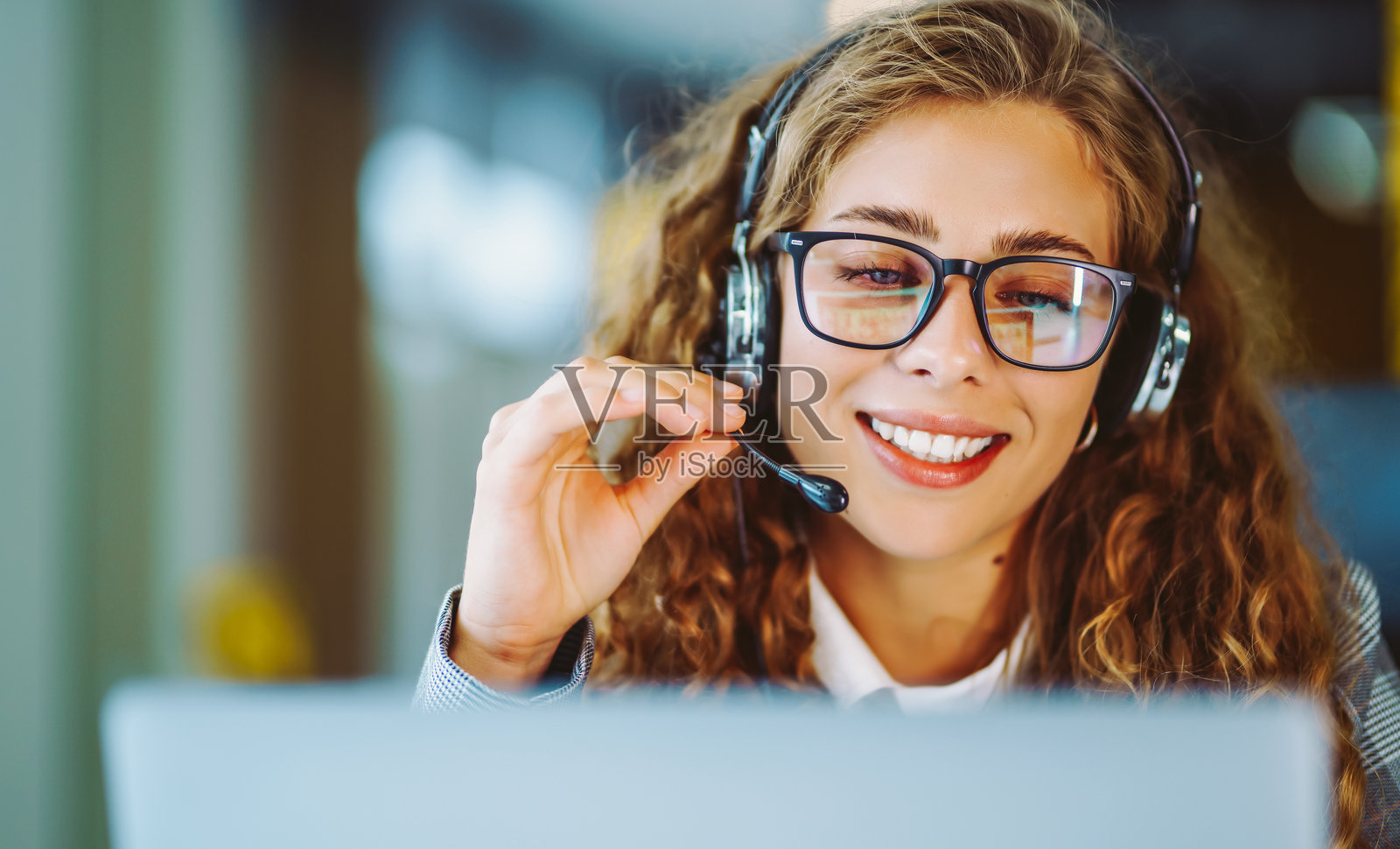 线上会议。年轻女子戴着耳机使用笔记本电脑观看网络研讨会或进行视频聊天。照片摄影图片