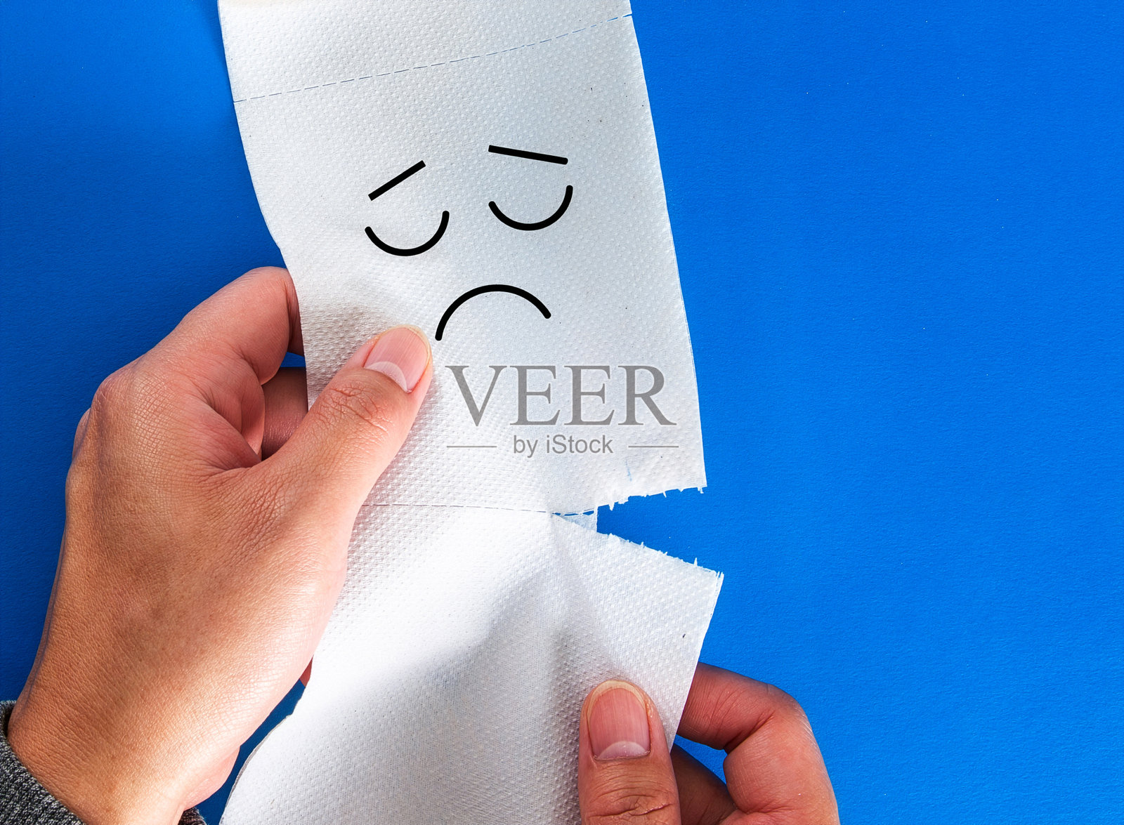 撕下悲伤表情的卫生纸卷照片摄影图片