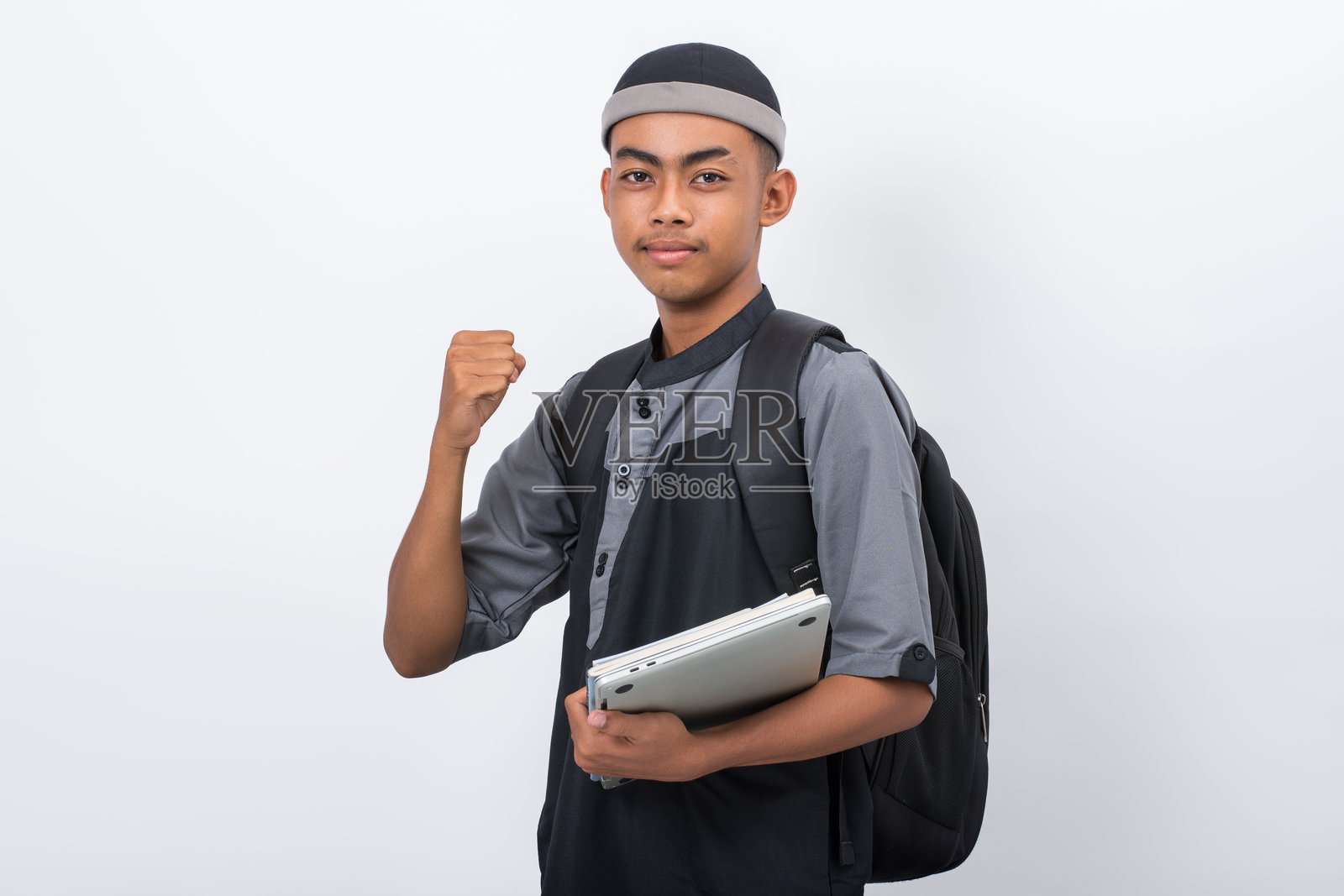 年轻的伊斯兰学校学生，在白色的背景上，快乐而兴奋地庆祝胜利照片摄影图片