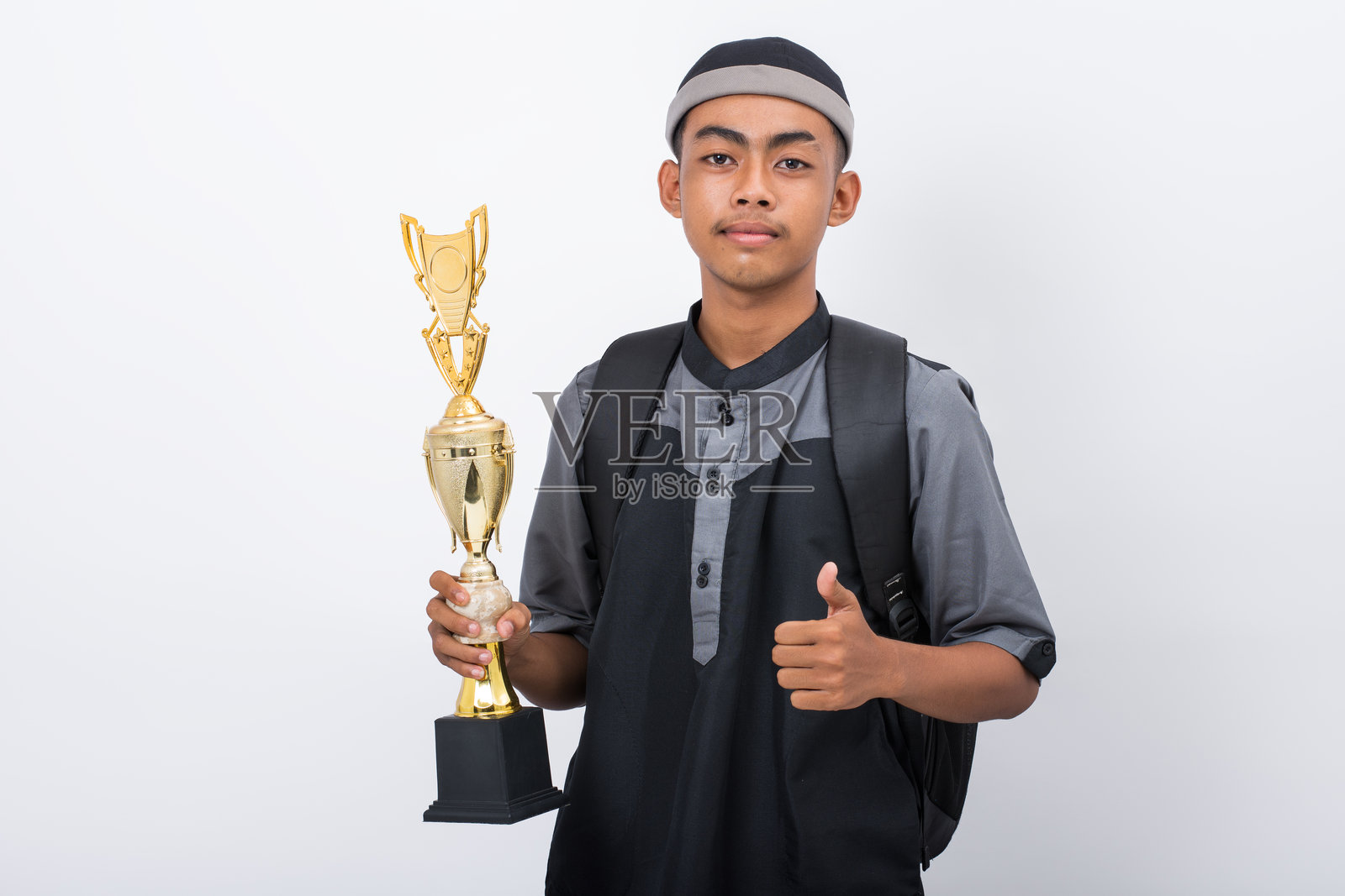 一名年轻的马德拉萨学生微笑着举着奖杯照片摄影图片