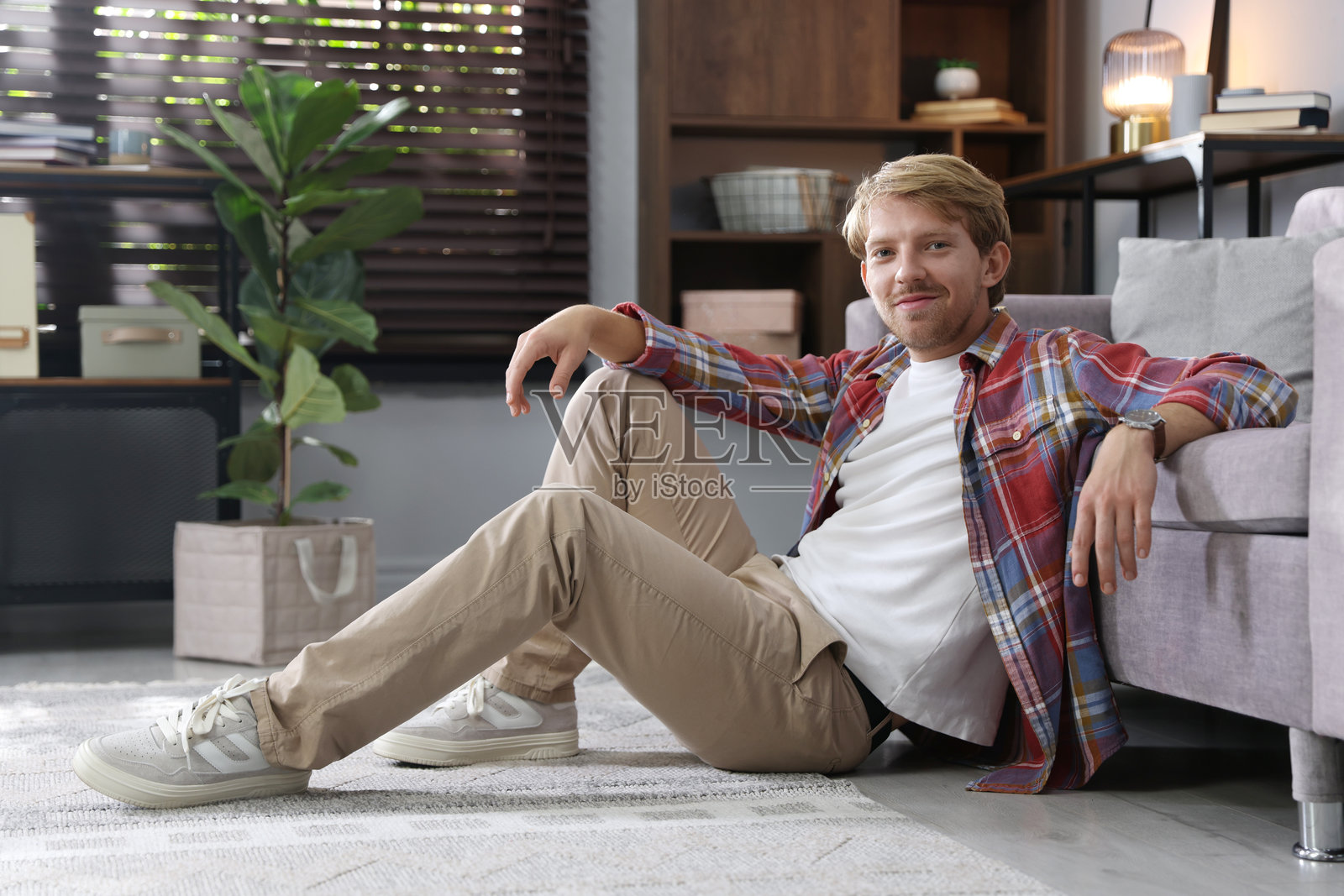 年轻男子在家中坐在地板上照片摄影图片
