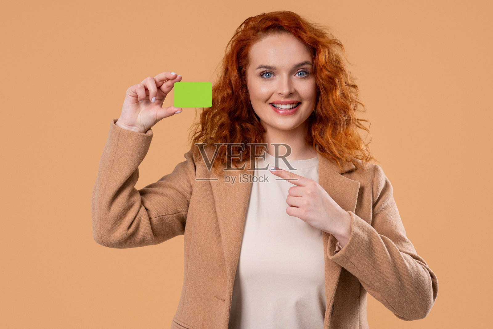 成功的女经理展示无限额度的绿色信用卡，用于支付和购买。样机照片摄影图片