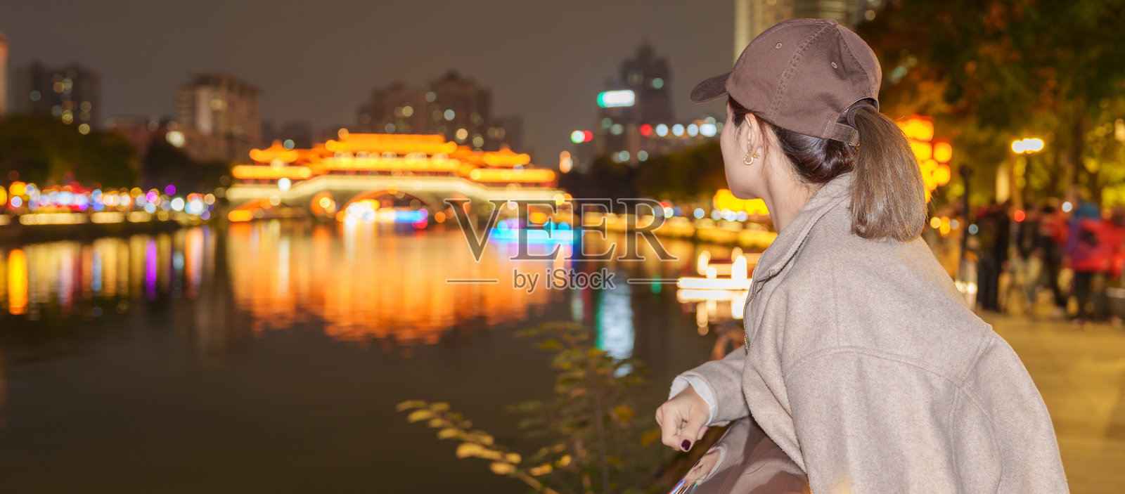 快乐的女游客在中国四川成都旅行，夜晚游览安顺桥，这是当地著名的旅游景点。照片摄影图片