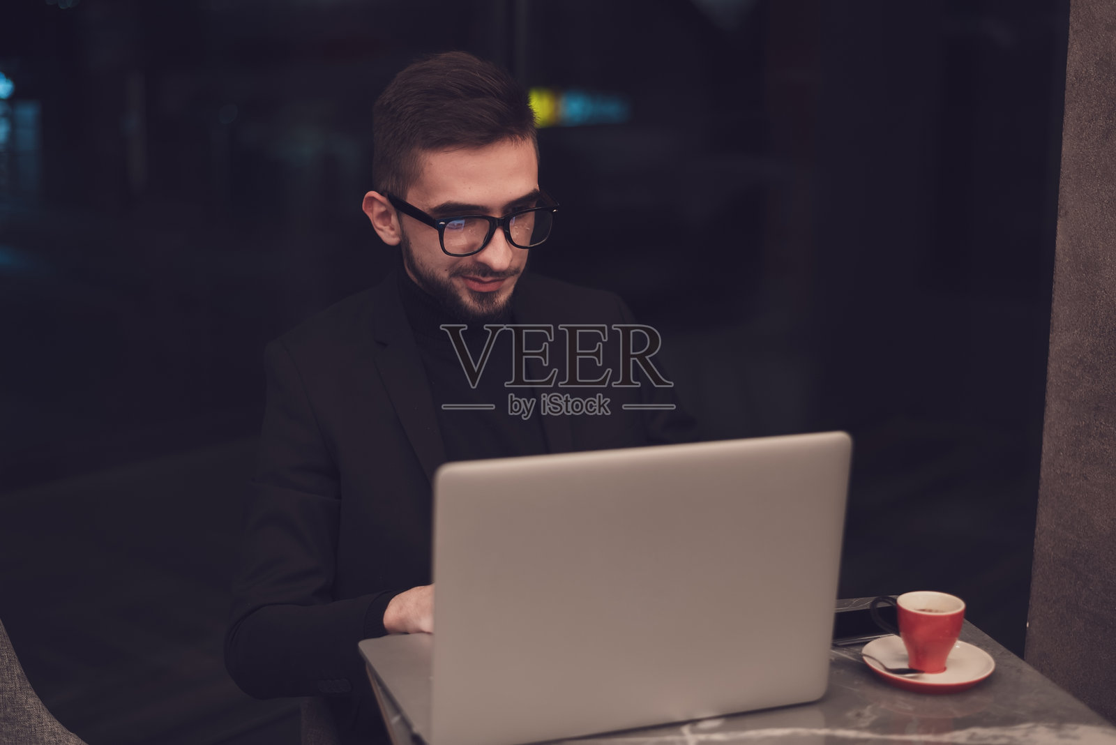 年轻的商务人士在他的办公室里用笔记本电脑工作。照片摄影图片