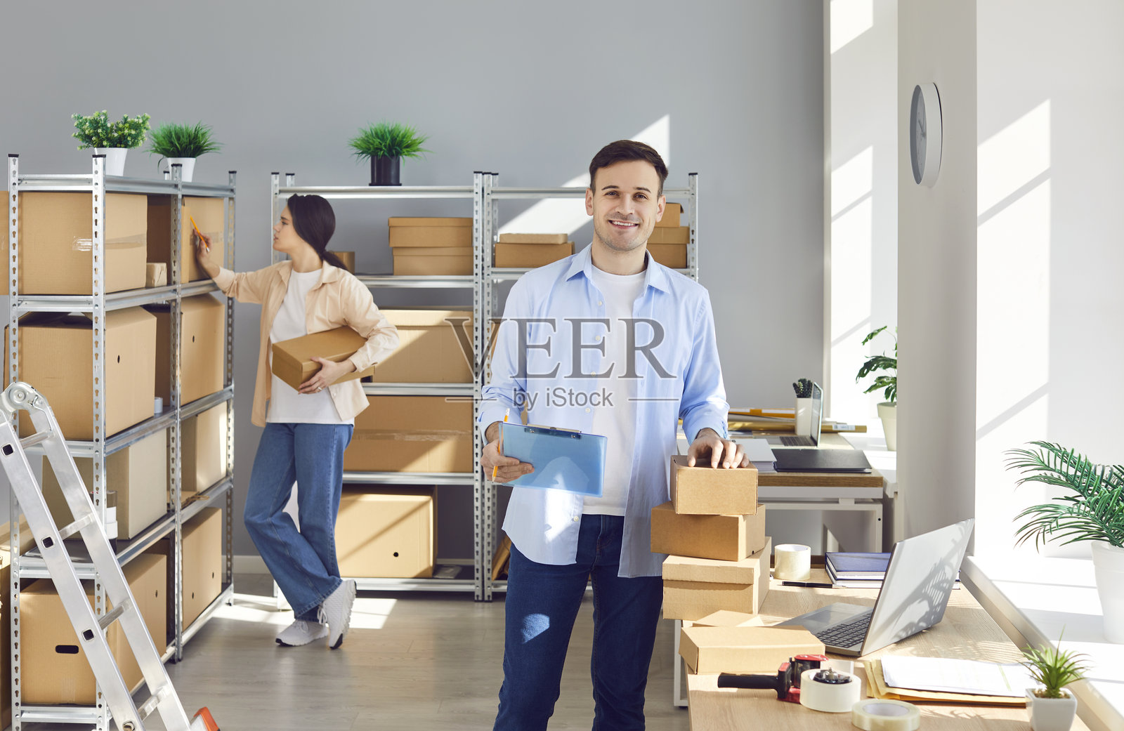 在线商店的库存管理员正在堆满纸箱的仓库里工作照片摄影图片