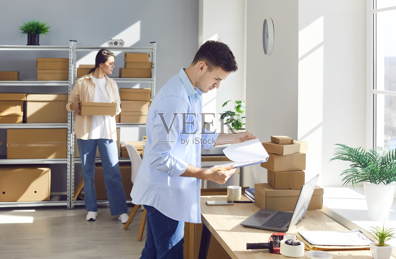 仓库或邮局里工作的男人正在清点包裹照片摄影图片