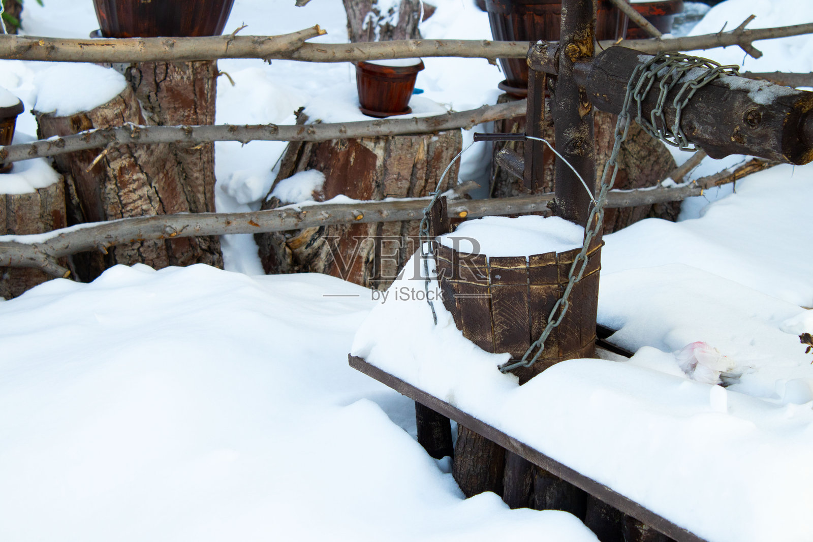 雪景冬季中带有链条和水桶的乡村木质水井照片摄影图片