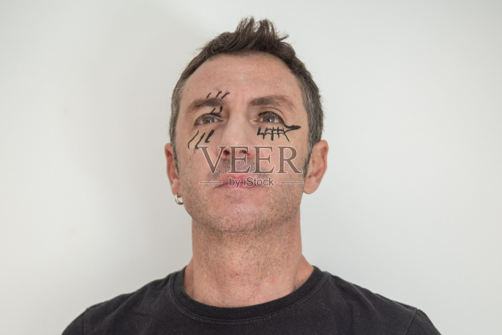 一位四十岁的白人男性，脸上化着狂欢节妆容。照片摄影图片