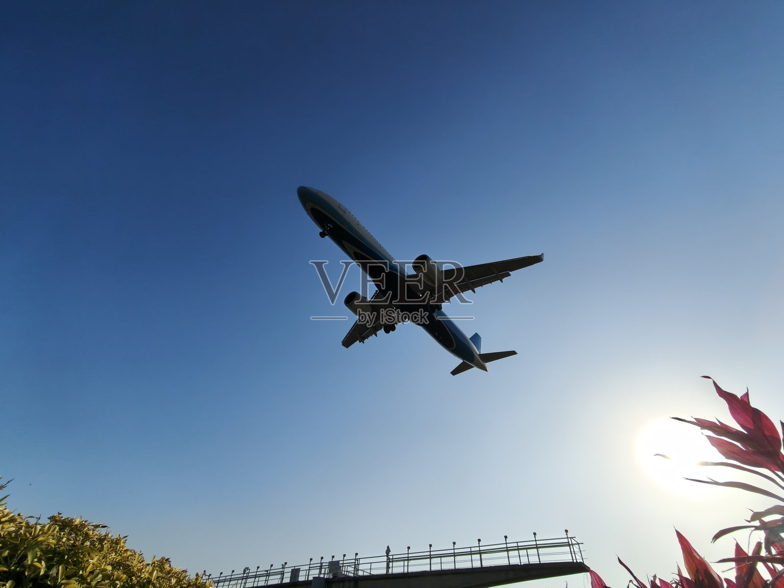 飞机在蓝天下起飞——低角度拍摄，有阳光照片摄影图片