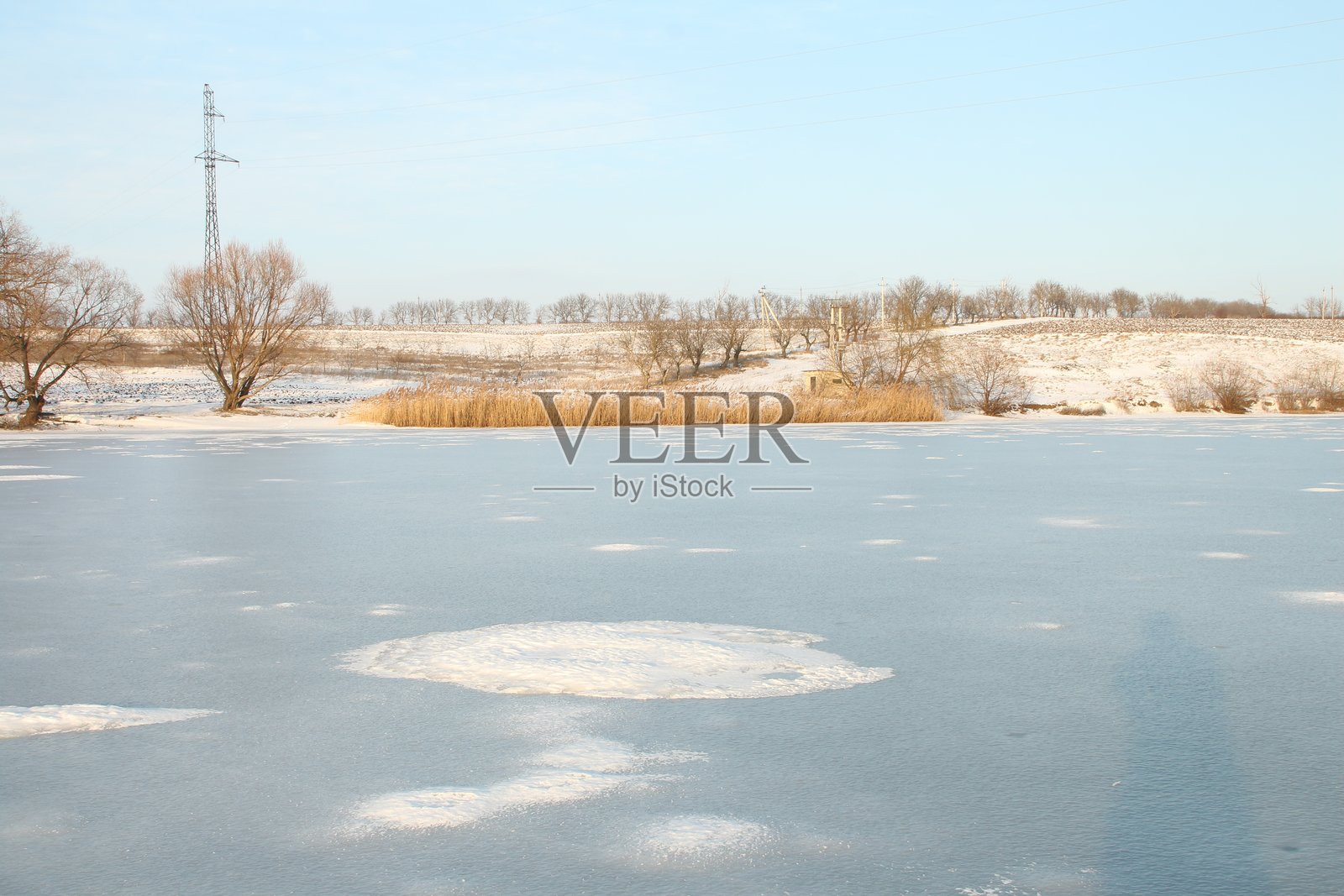 远处有树木和塔的雪地照片摄影图片