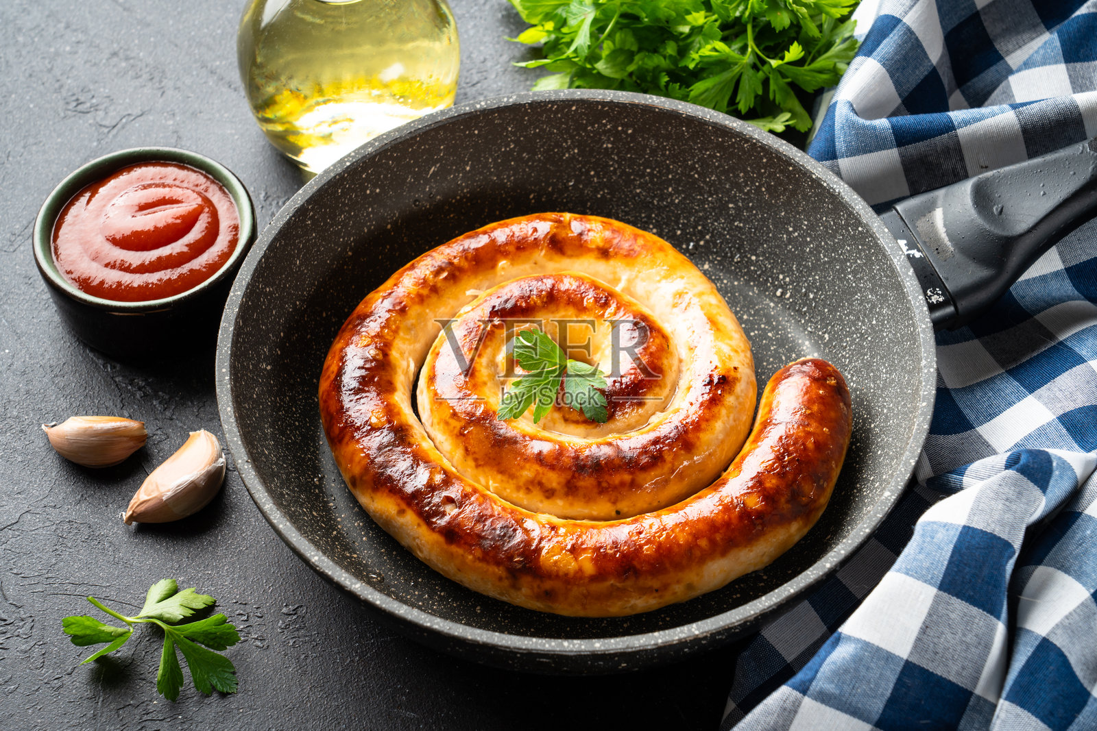 锅里烤着的香肠、烤肉、猪肉香肠，配有番茄酱。特写。照片摄影图片