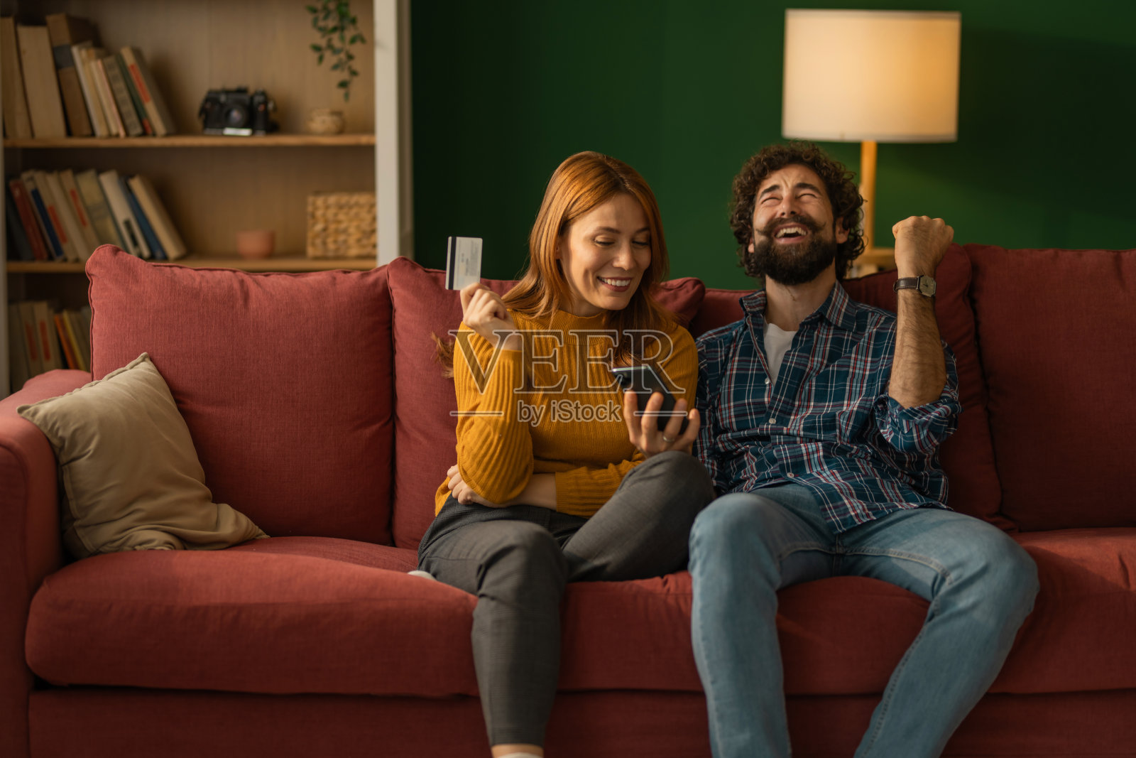 一对快乐的情侣在家成功地用信用卡进行网上购物照片摄影图片