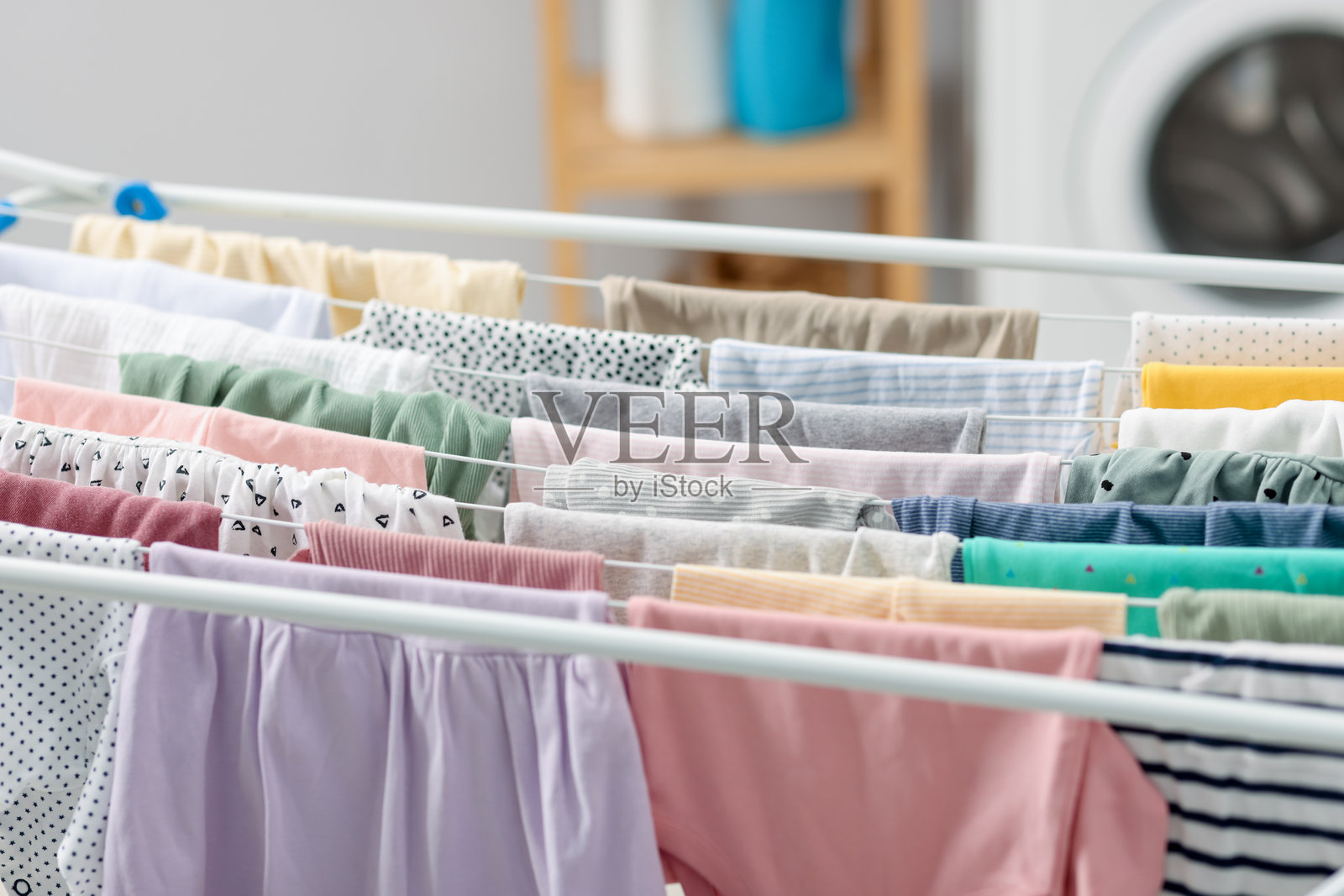 晾衣架上许多干净的婴儿服装，特写照片摄影图片