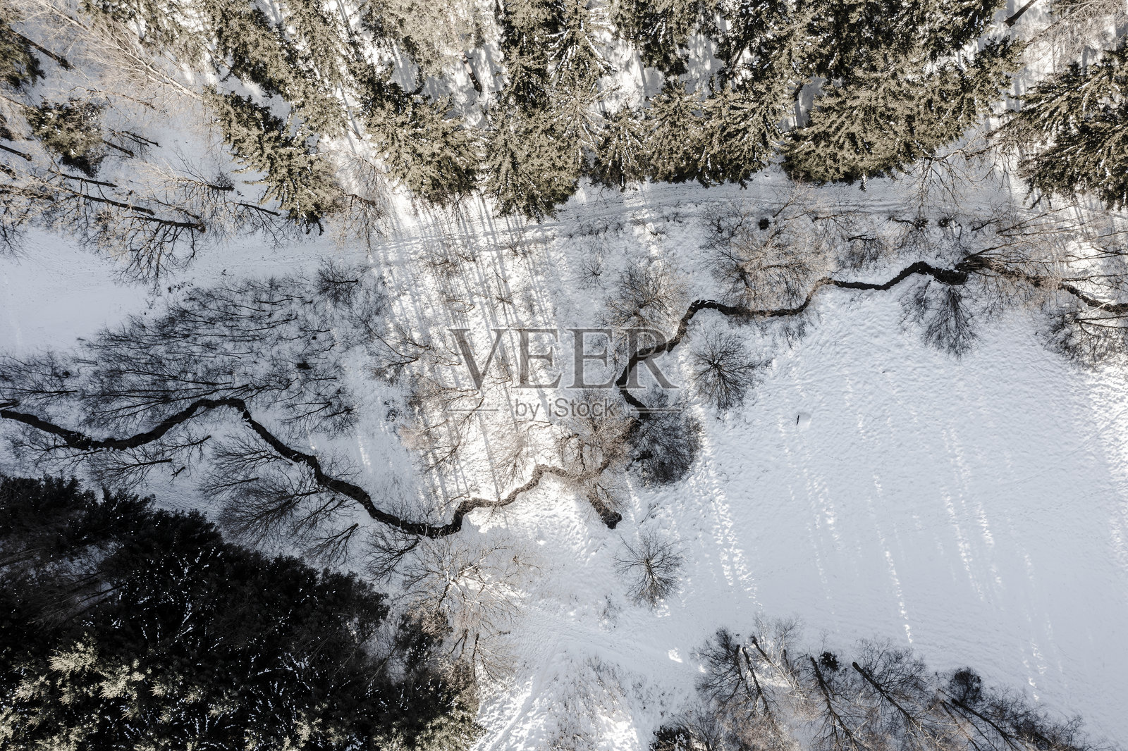 航拍的冬季乡村风景。雪景、溪流和森林。照片摄影图片